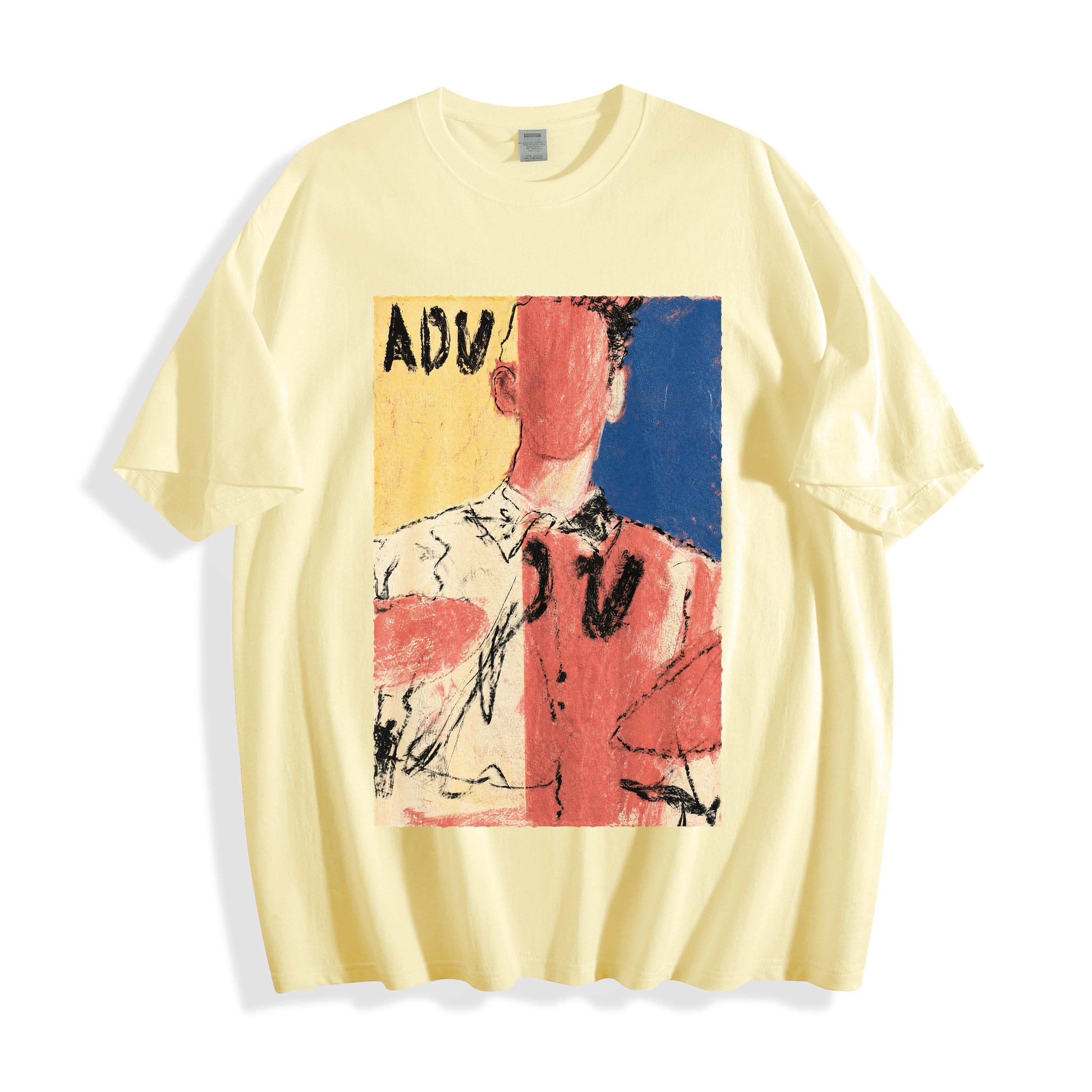 A flat lay of a butter yellow abstract faceless portrait graphic tee, contrasting a warm base color with the vivid abstract expressionism print.