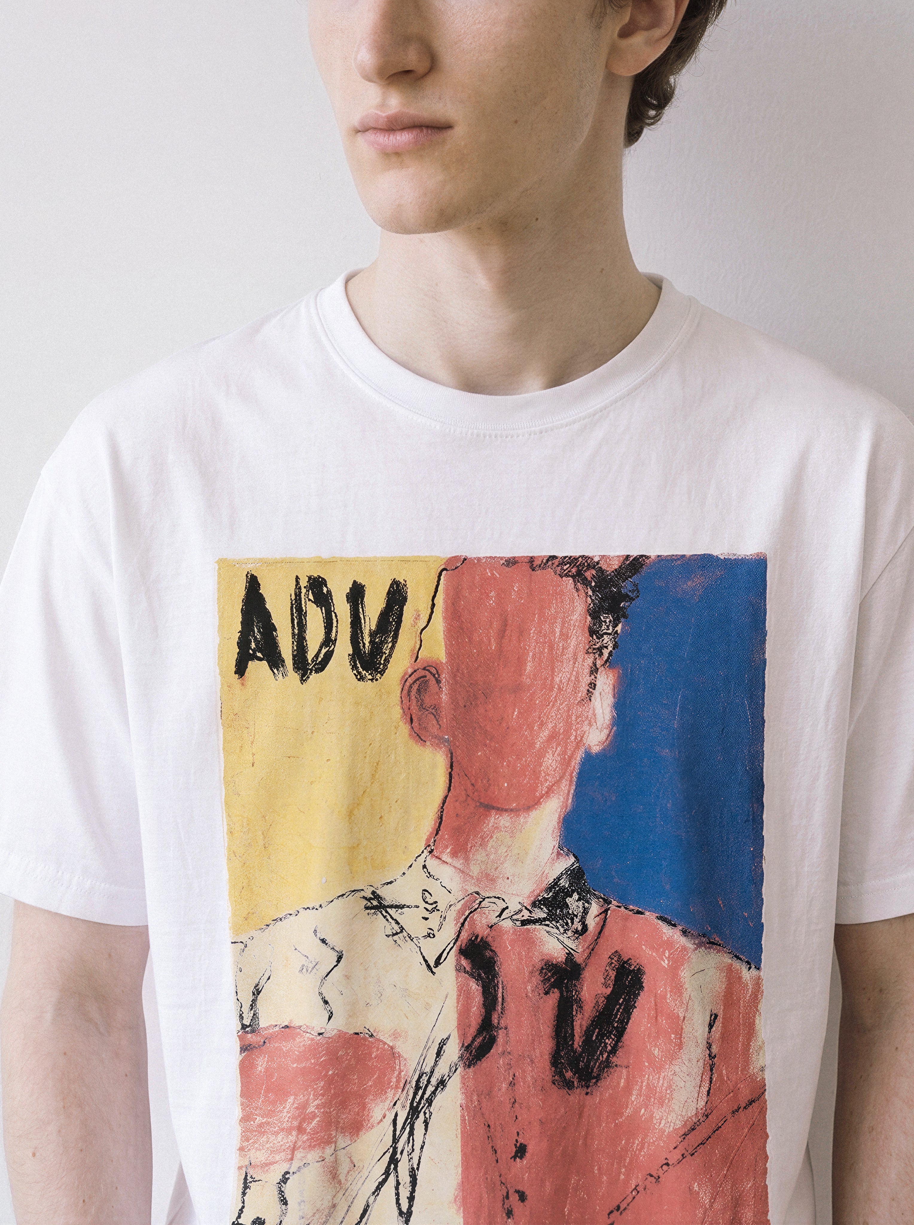 A close-up front view of a male model in a white abstract faceless portrait graphic tee, emphasizing the raw texture of the abstract expressionism graphic.