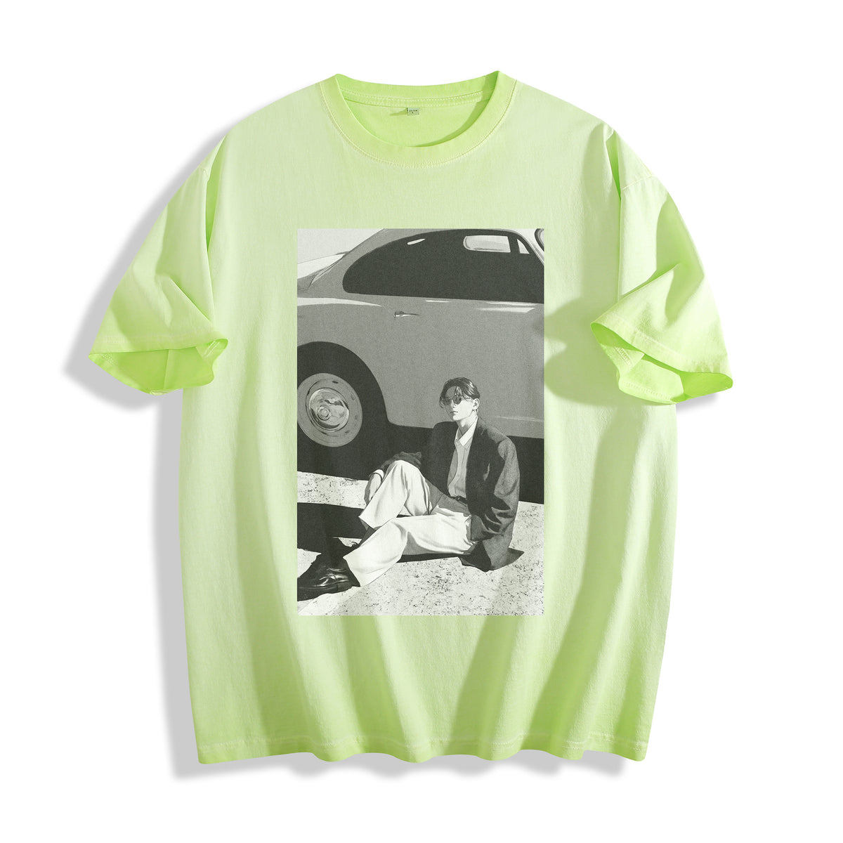 A neon yellow-green short-sleeve t-shirt with a striking 90s retro black and white photography print on the front showing a person sitting next to a car, displayed on a clean white background.