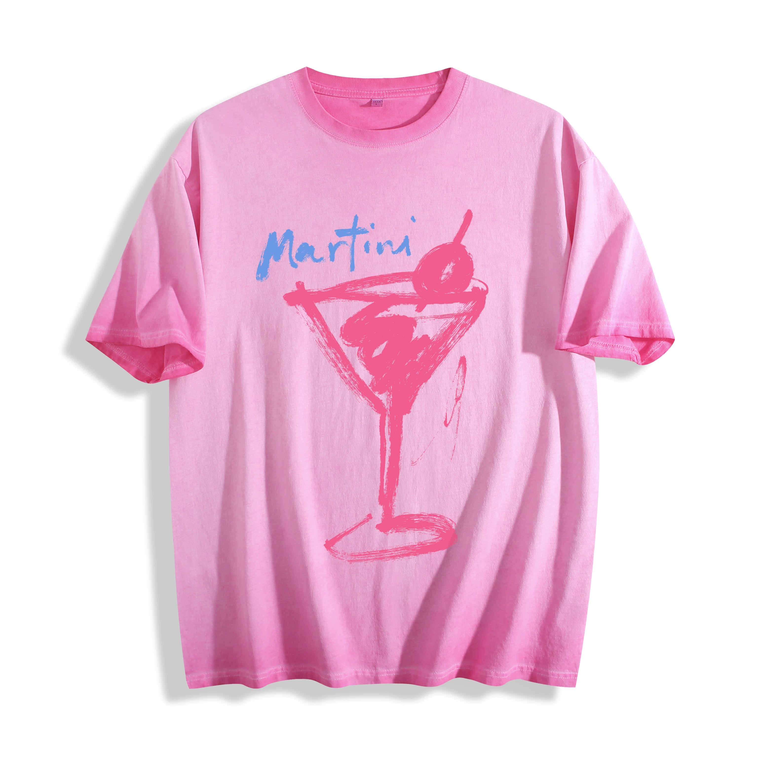 Flat lay product photography of an aura pink heavyweight boxy fit t-shirt showcasing a bold raw ink stroke martini glass sketch and blue typography.
