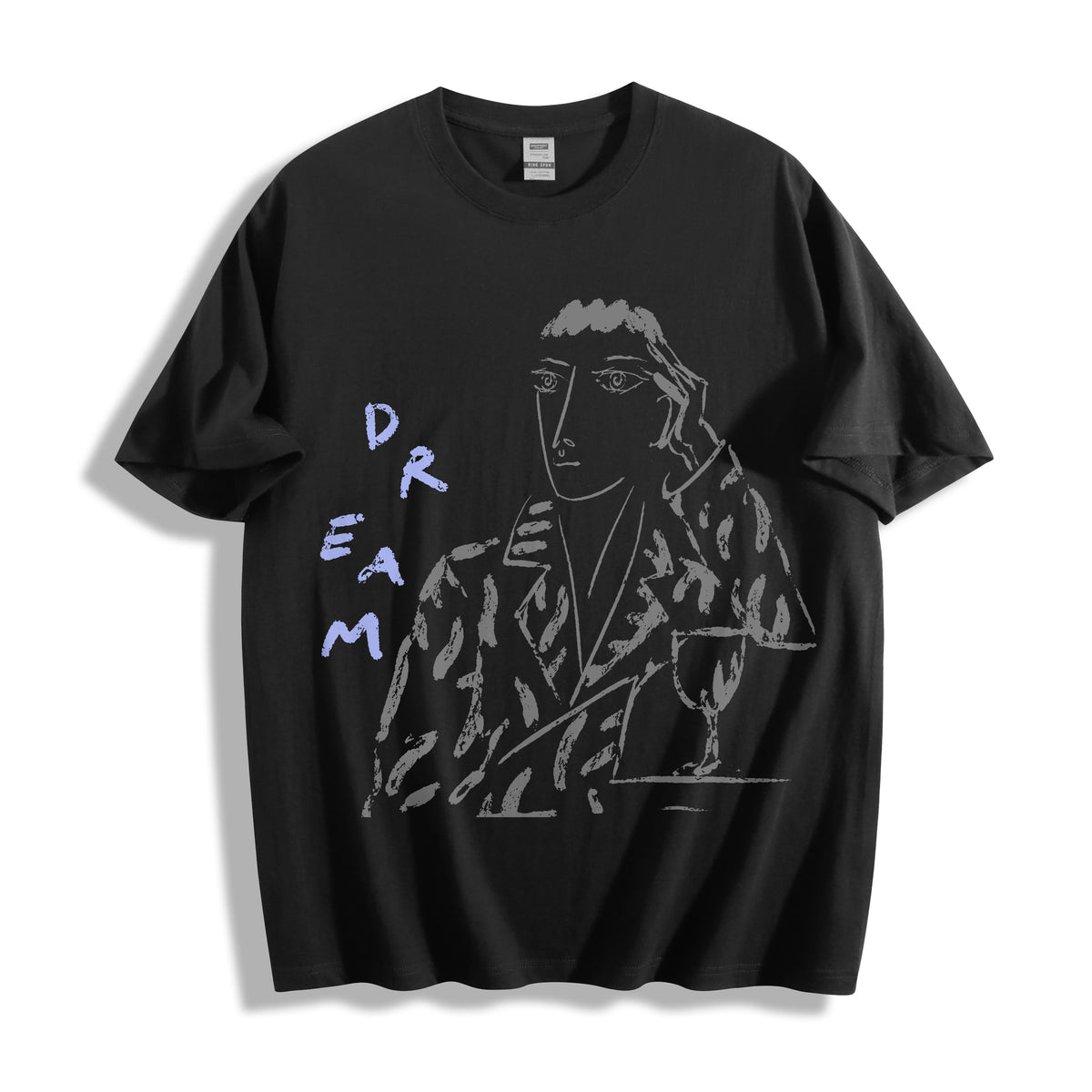 Flat lay product photography of a black heavyweight boxy fit graphic tee highlighting a contrasting charcoal-style portrait and bold text design.