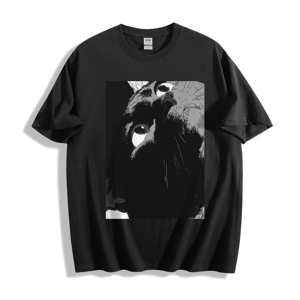 Top-down flat lay view of a black heavyweight boxy fit streetwear t-shirt displaying a striking monochrome high-tension close-up stare illustration.