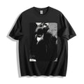 Top-down flat lay view of a black heavyweight boxy fit streetwear t-shirt displaying a striking monochrome high-tension close-up stare illustration.