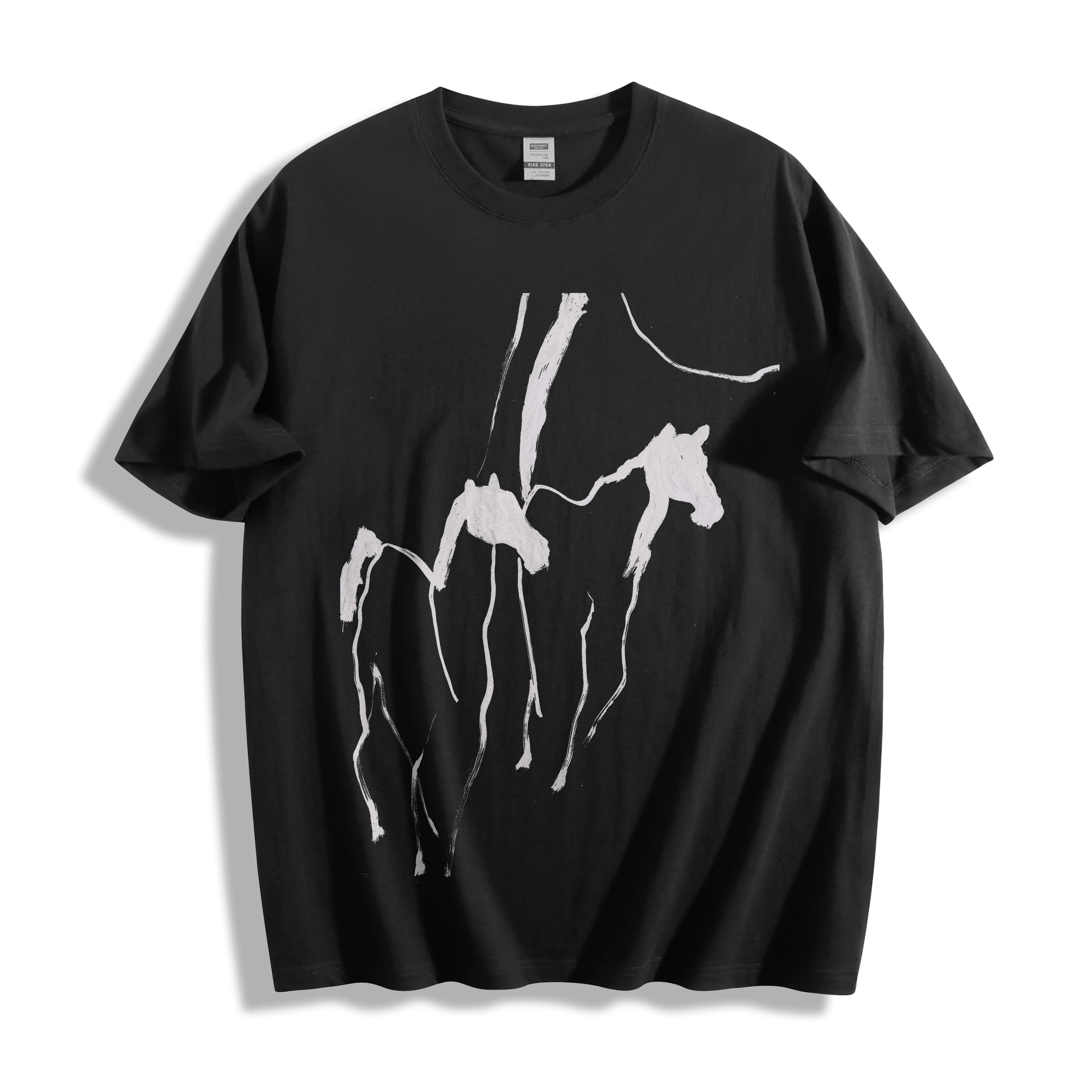 Flat lay product photography of a black oversized t-shirt showcasing a sweeping abstract brush stroke wild horses graphic.