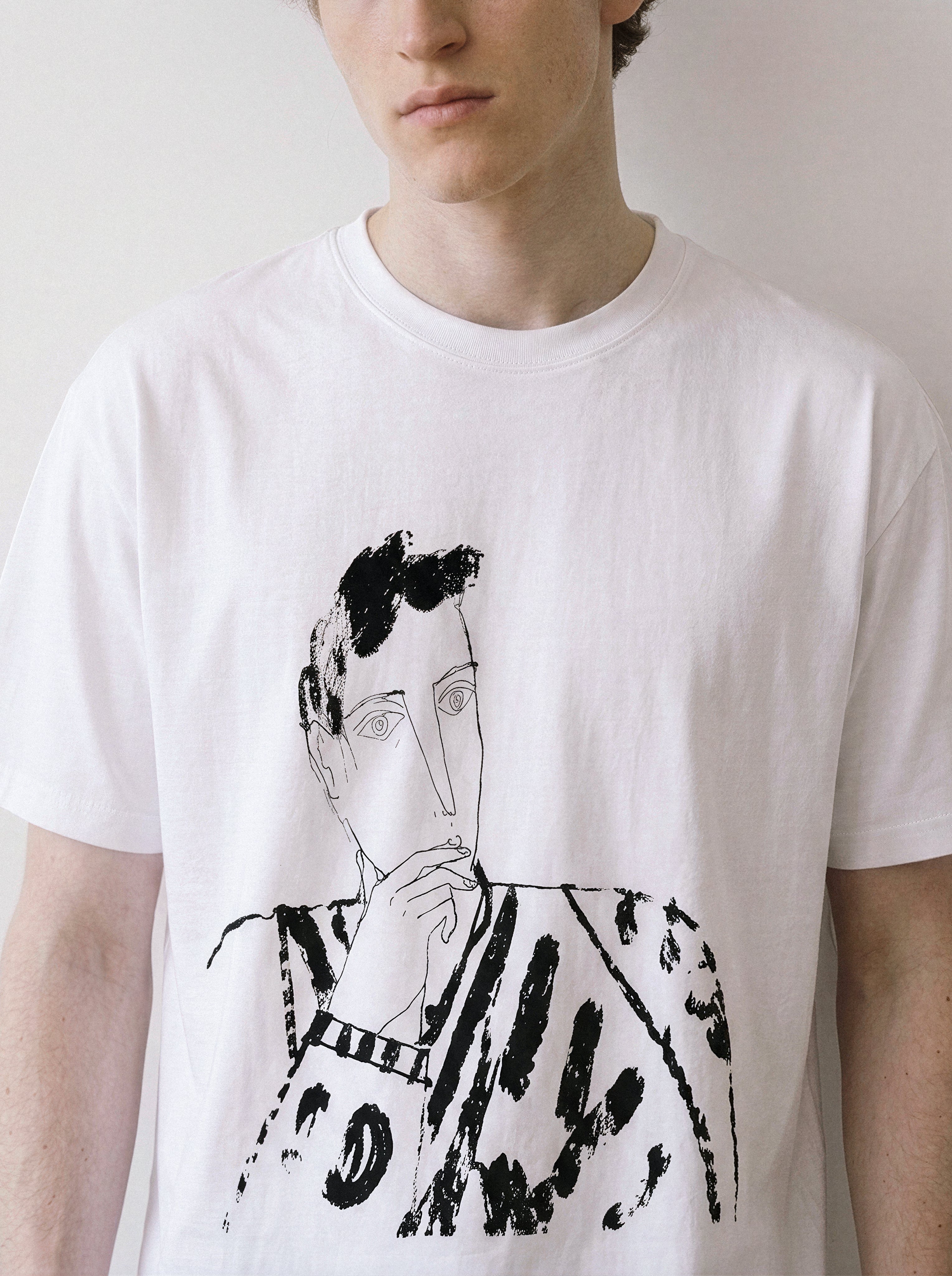 A close-up front view of a male model in a white blank stare portrait line art graphic tee, highlighting the raw ink illustrations and pure line art form.