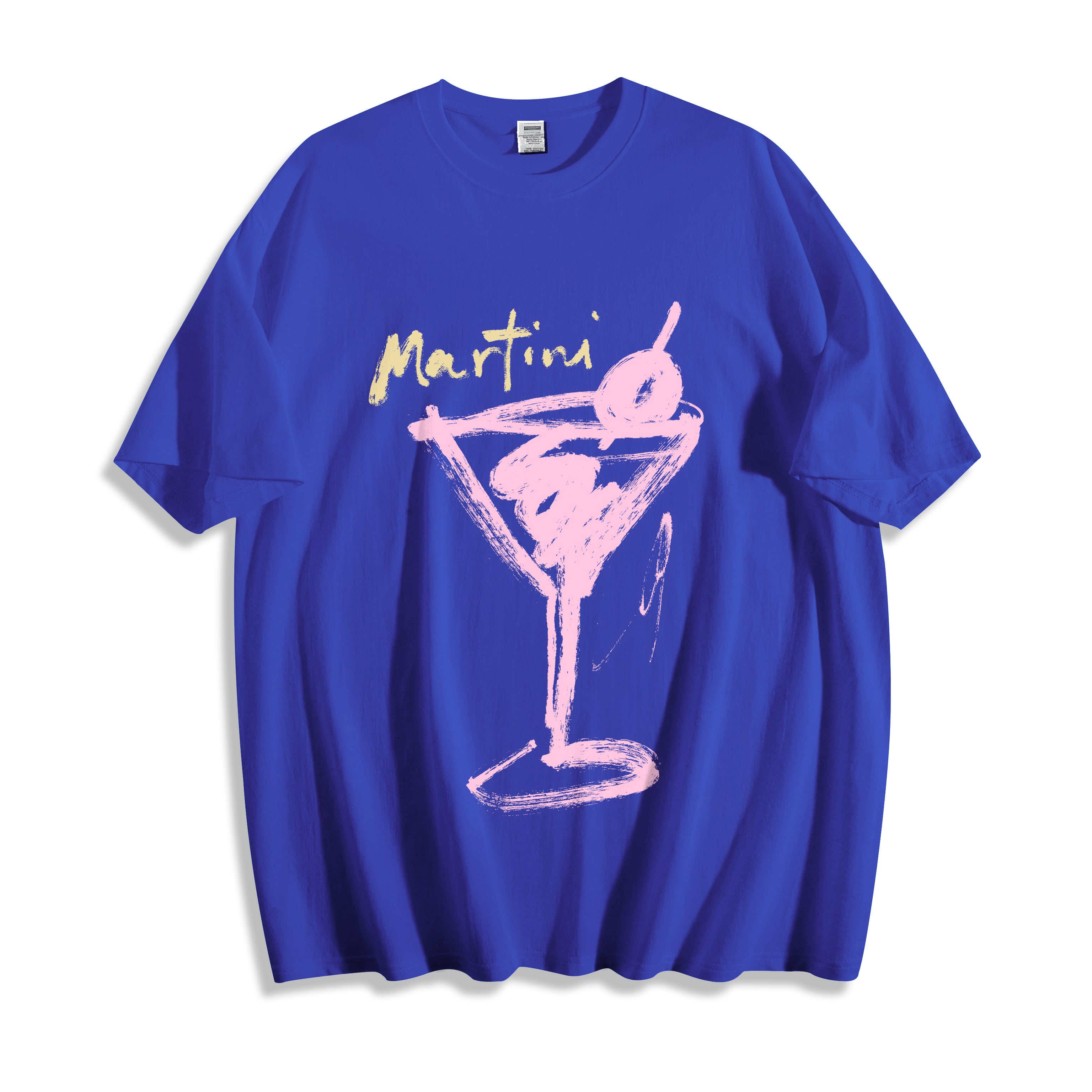 Top-down flat lay view of a blue streetwear t-shirt featuring a unique stylized martini glass line art graphic and the word 'Martini' in yellow script across the chest, shown on a plain white background.