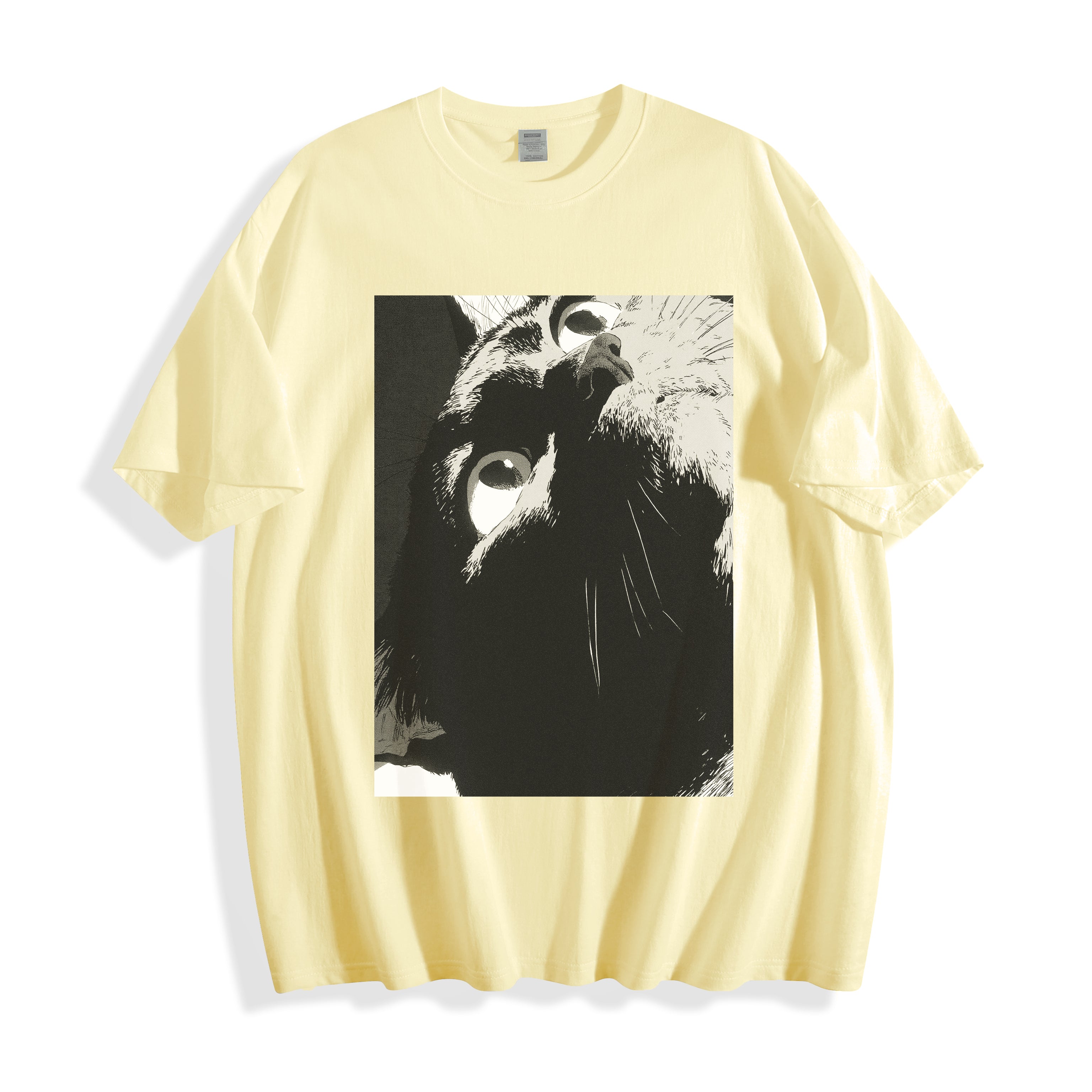 A flat lay of a butter yellow cat gaze manga panel graphic tee, contrasting a warm base color with the bold pure line art feline design.