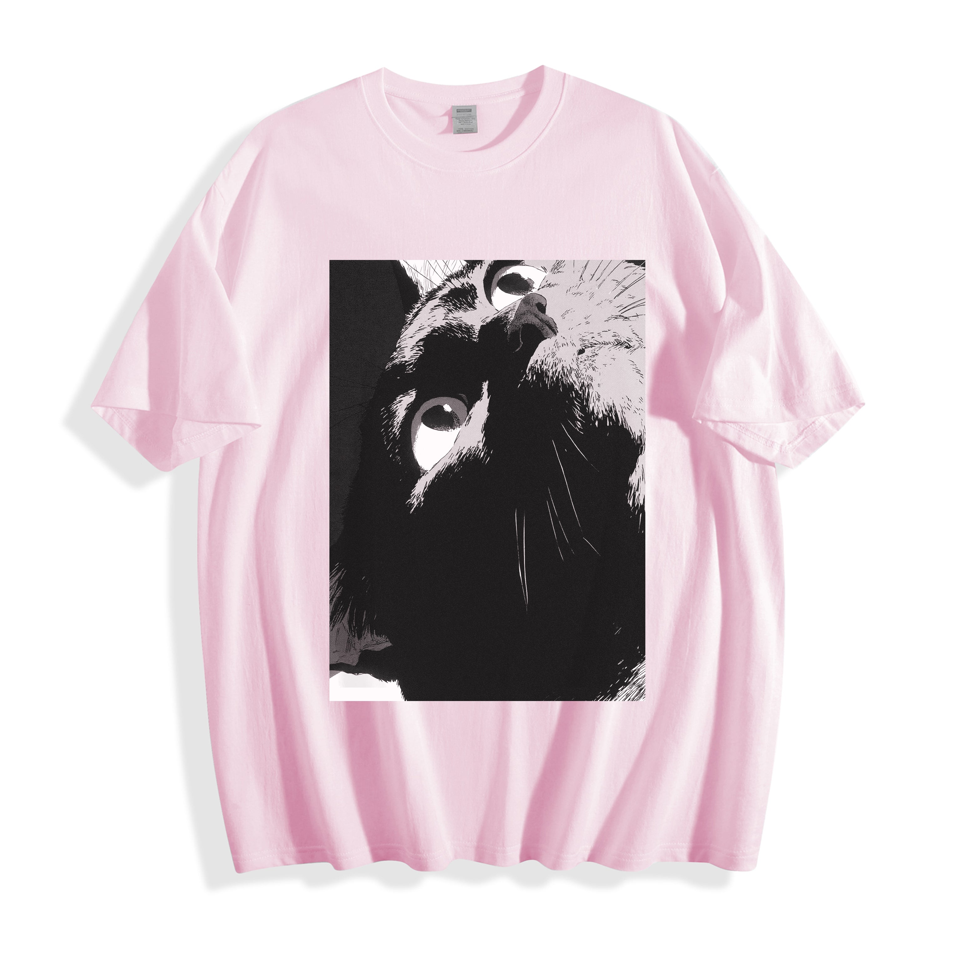 A flat lay of a light pink cat gaze manga panel graphic tee, blending soft pastel tones with a striking raw independent manga aesthetic.