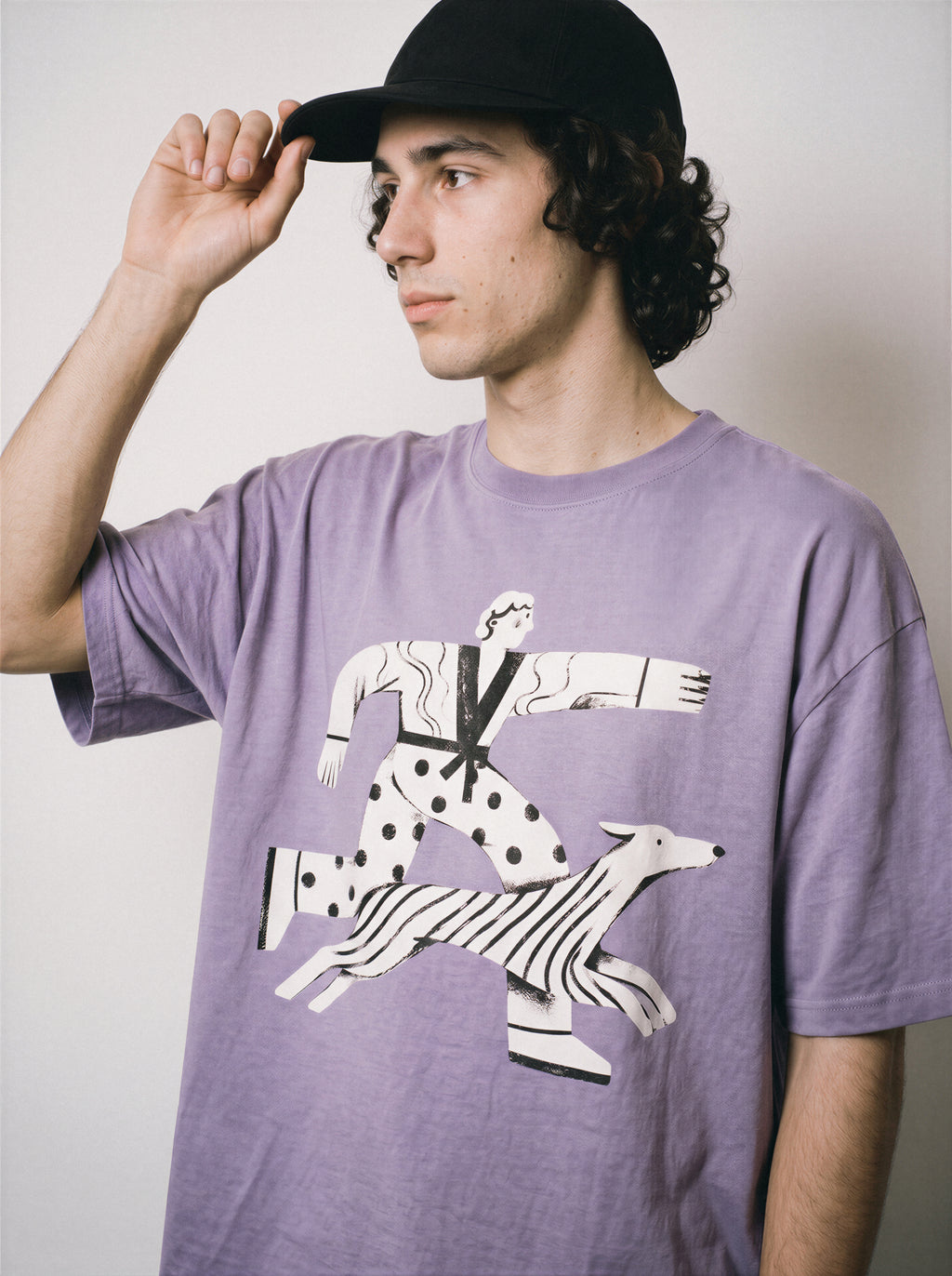 A male model looking away wearing an ombre violet confident stride boy and dog graphic tee, displaying the dynamic walking forward print and positive streetwear look.
