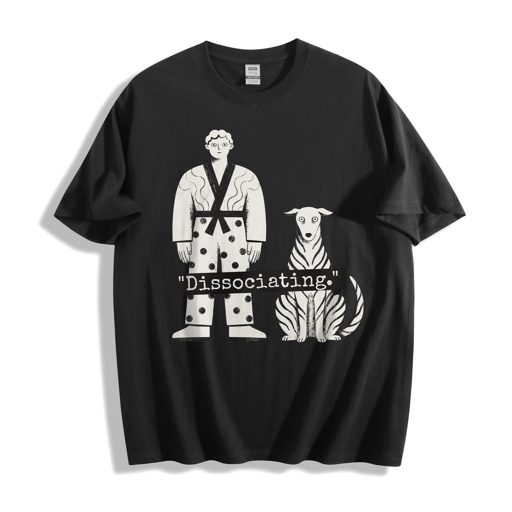 A flat lay of a black dissociating ironic graphic tee, contrasting a dark background with the high-contrast sarcastic meme streetwear print.