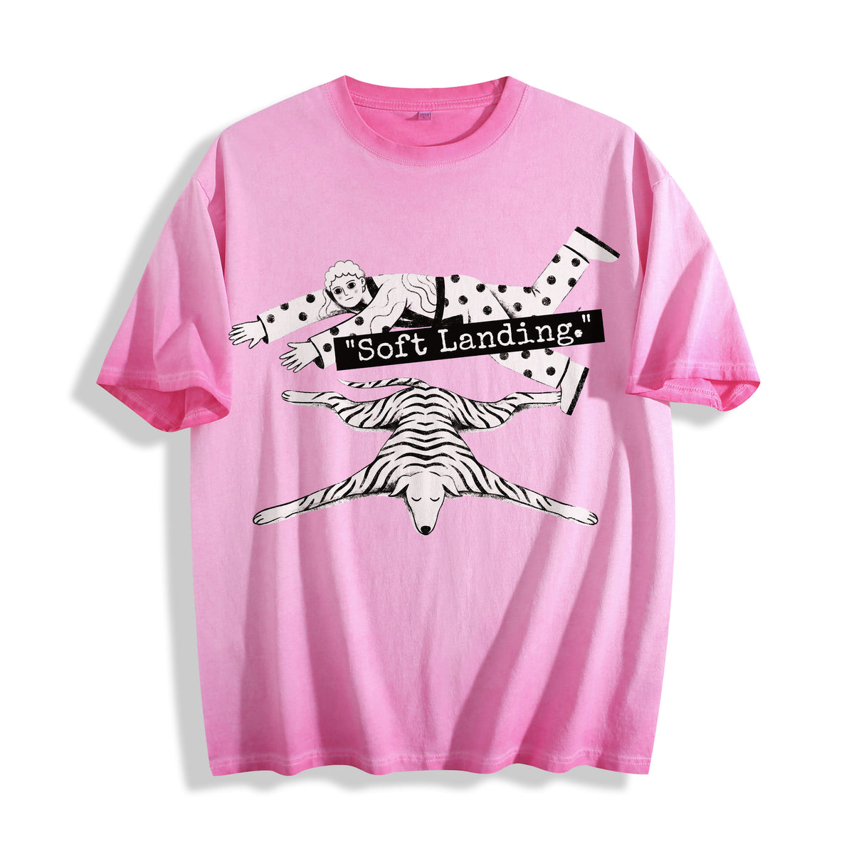A flat lay of an aura pink face down soft landing graphic tee, contrasting a soft pastel tone with the objective economic miracle graphic design.
