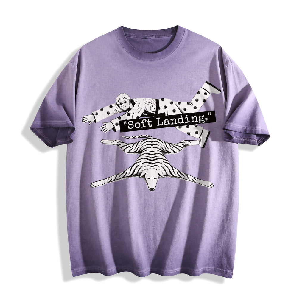 A flat lay of an ombre violet face down soft landing graphic tee, featuring the deadpan boy and dog lying flat print depicting an economic miracle.