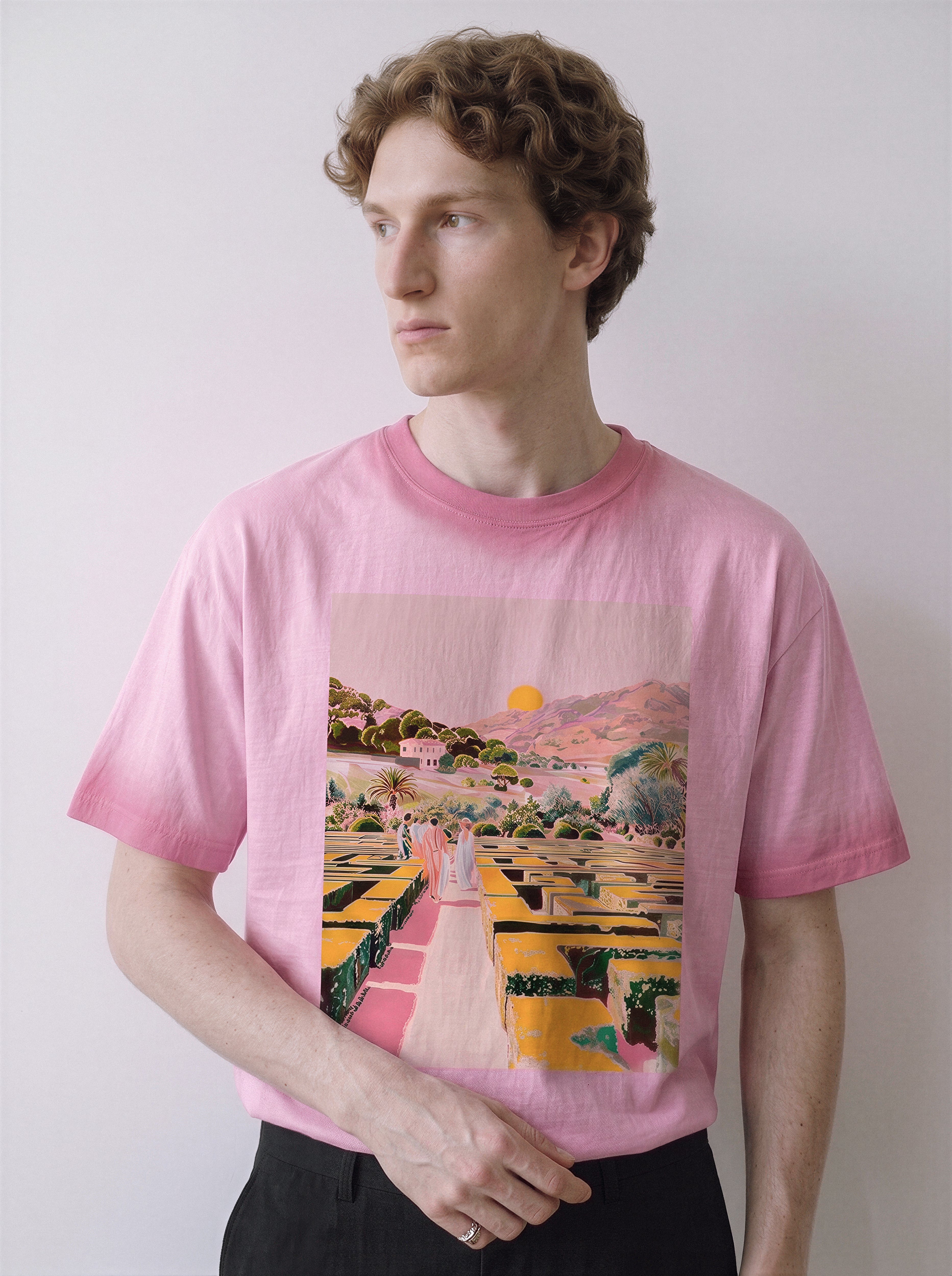A male model looking to the right wearing an aura pink geometric labyrinth graphic novel tee, highlighting the chromatic tension and psychological streetwear vibe.