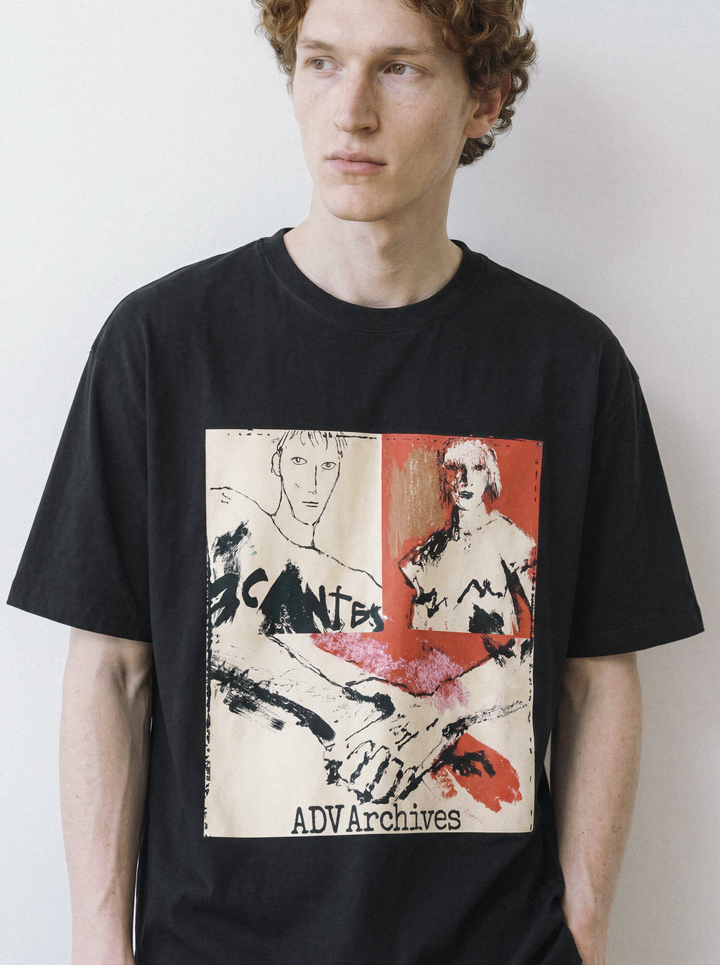 A front view of a male model wearing a black handshake portrait mixed media graphic tee, highlighting the bold color blocks and raw sketch illustrations.