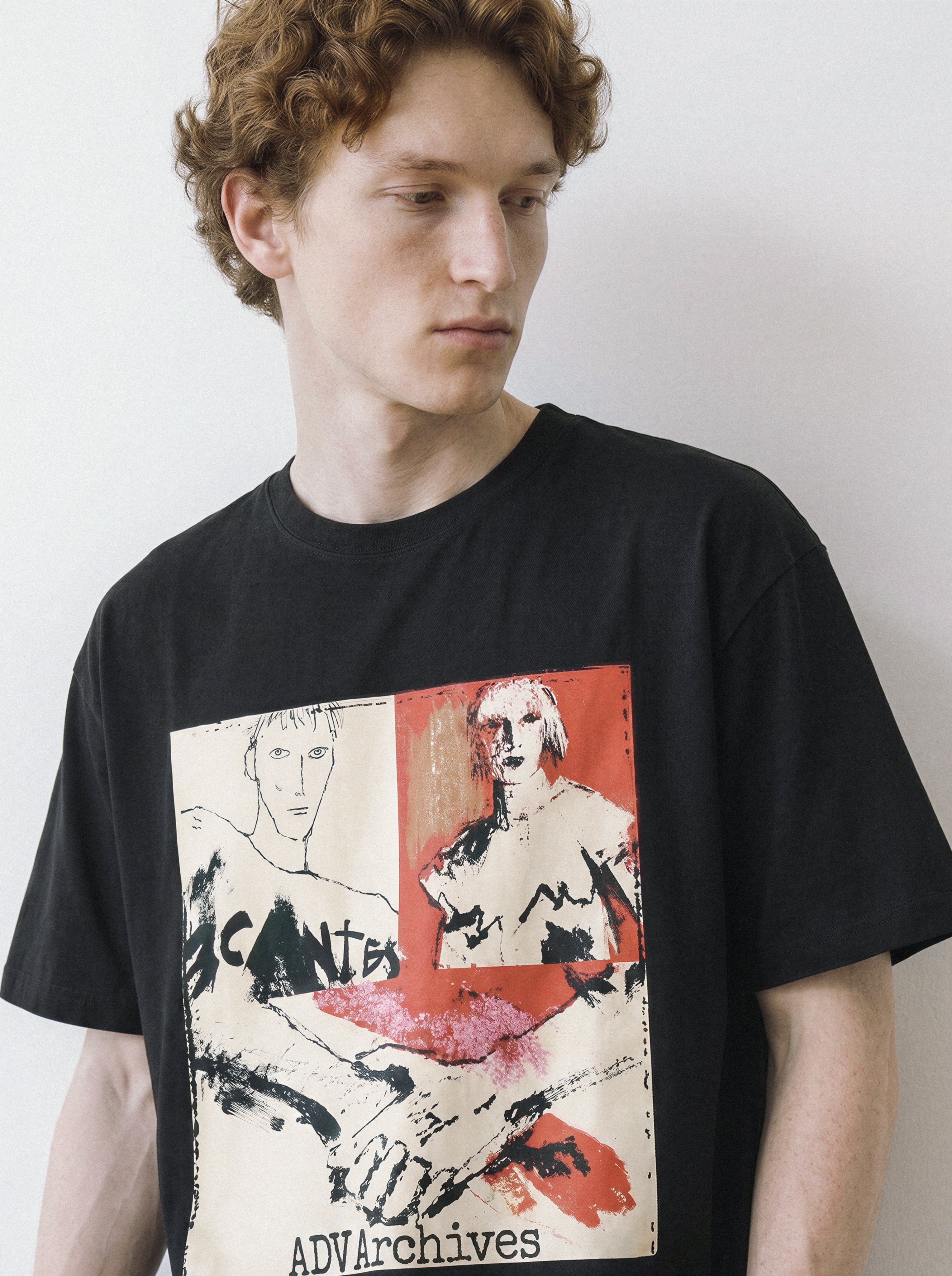 A male model looking down wearing a black handshake portrait mixed media graphic tee, showcasing the grunge streetwear aesthetic and heavy screenprint texture.
