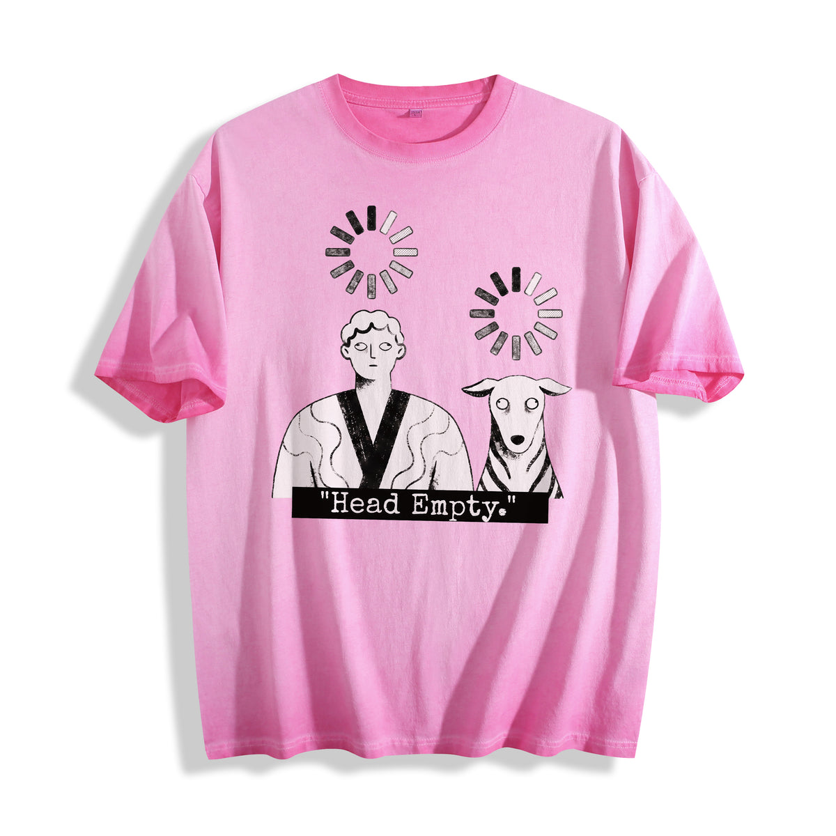 A flat lay of an aura pink head empty buffering icon graphic tee, contrasting a soft pastel tone with the offline corporate burnout aesthetic.