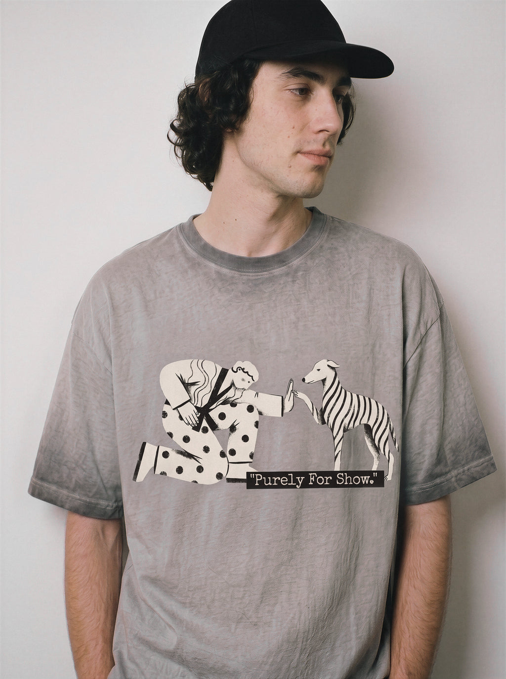 A male model looking away wearing an ombre grey ironic high five graphic tee, emphasizing the relaxed boxy fit and sarcastic introvert streetwear aesthetic.