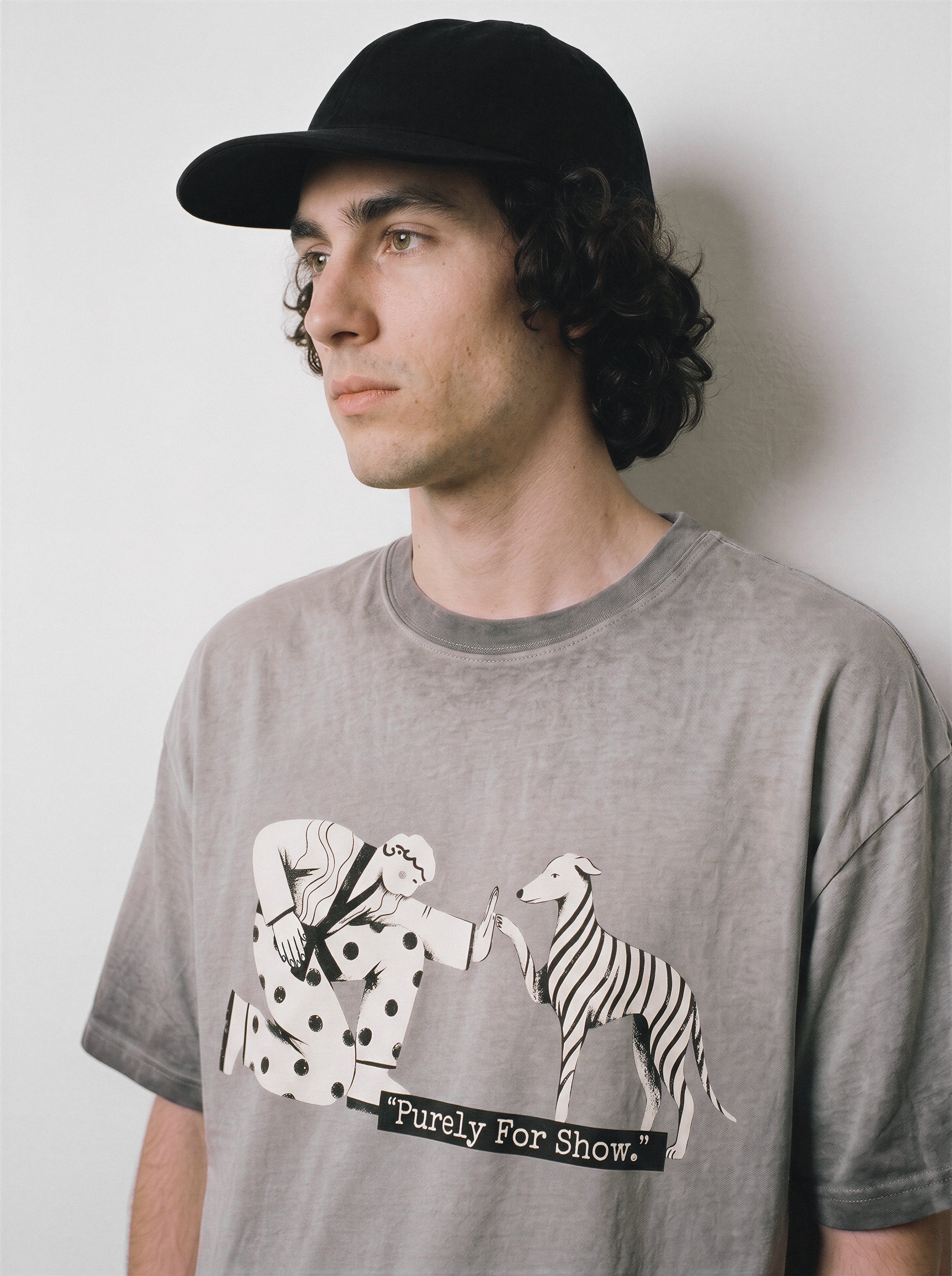 A side profile of a male model wearing an ombre grey ironic high five graphic tee, featuring the sarcastic boy and dog print and tired of fakeness mood.
