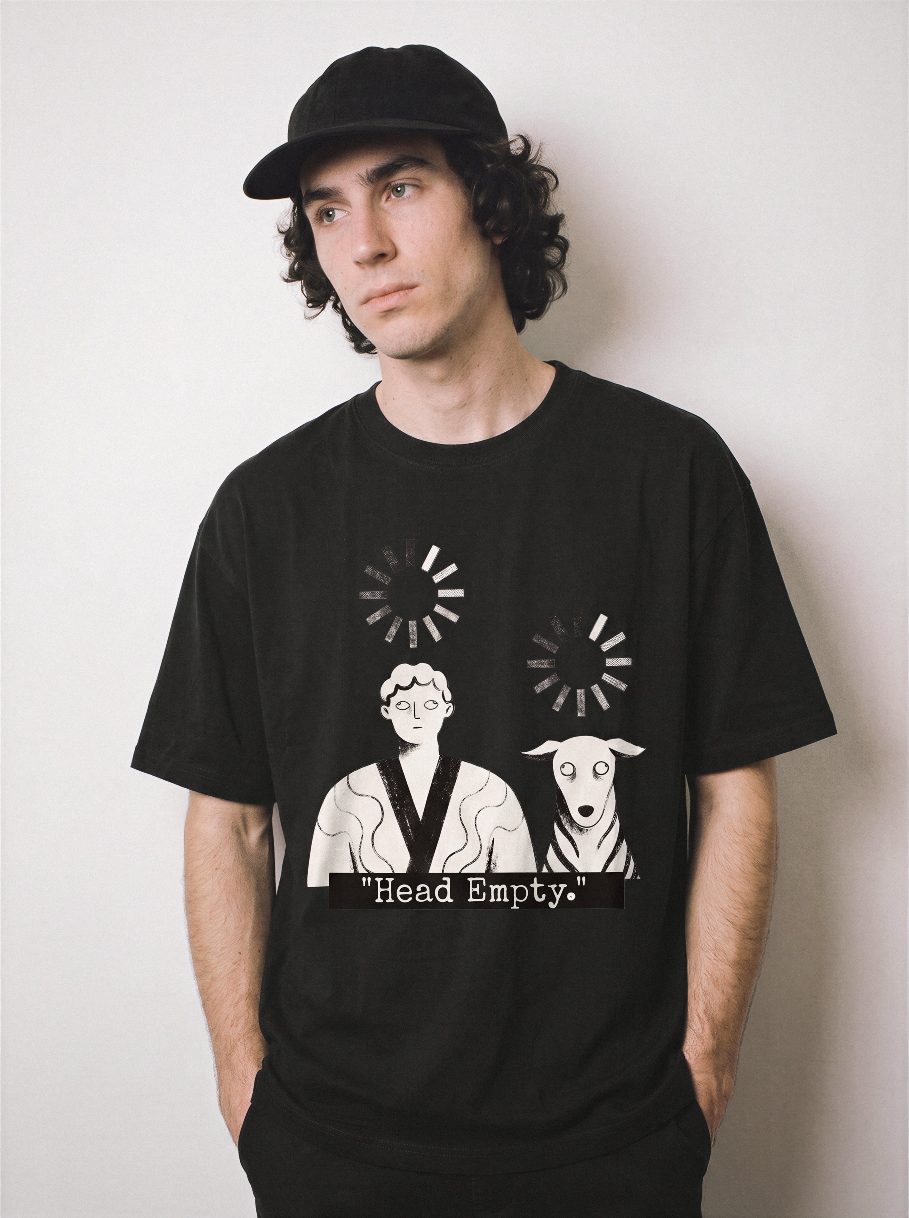 A male model with hands in pockets standing wearing a black loading wheel graphic tee, highlighting the system crashed vibe and relaxed boxy fit.