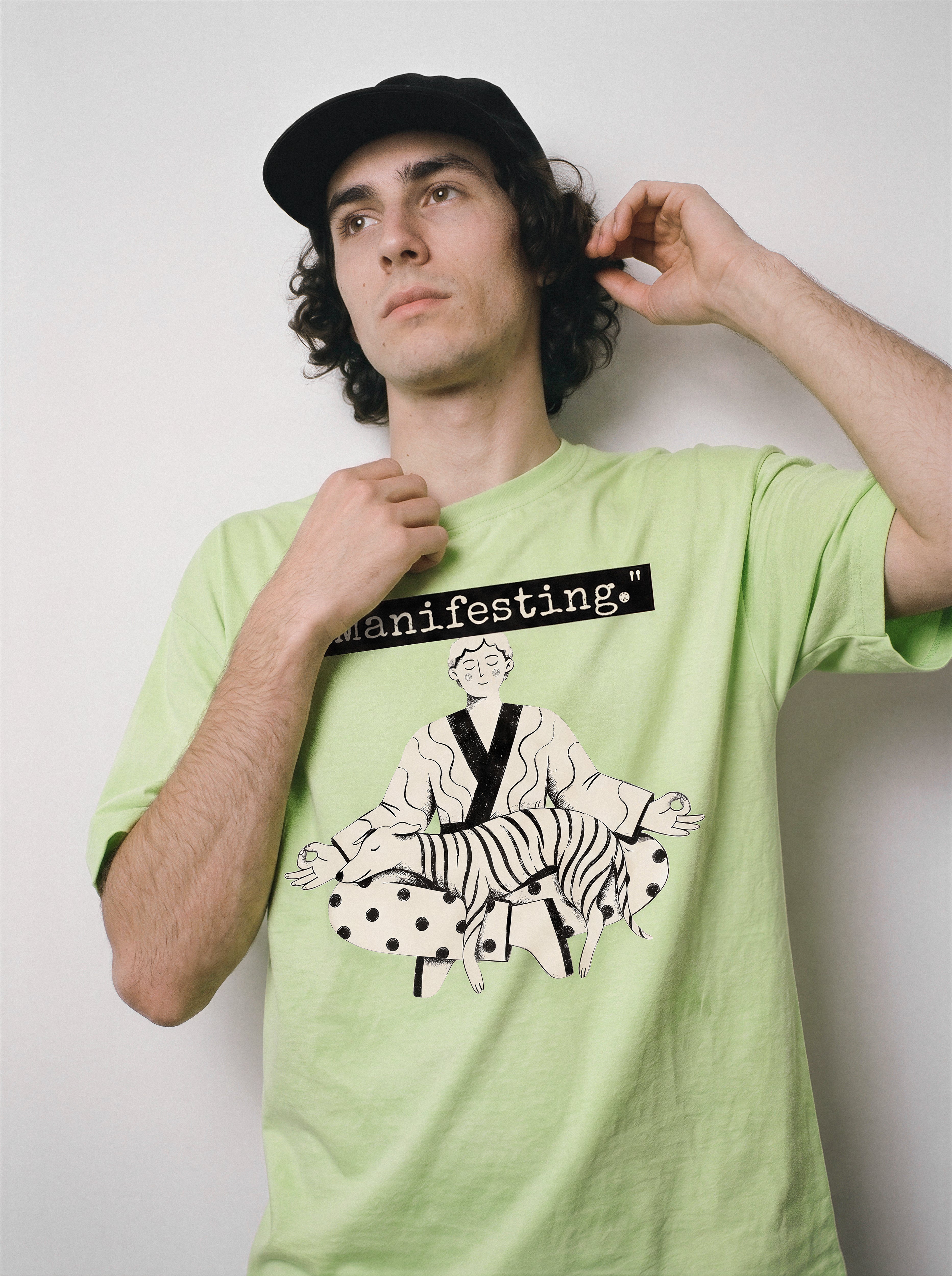 A male model adjusting his collar wearing an acid lime manifesting meditating graphic tee, displaying the casual drape and detached state of mind aesthetic.