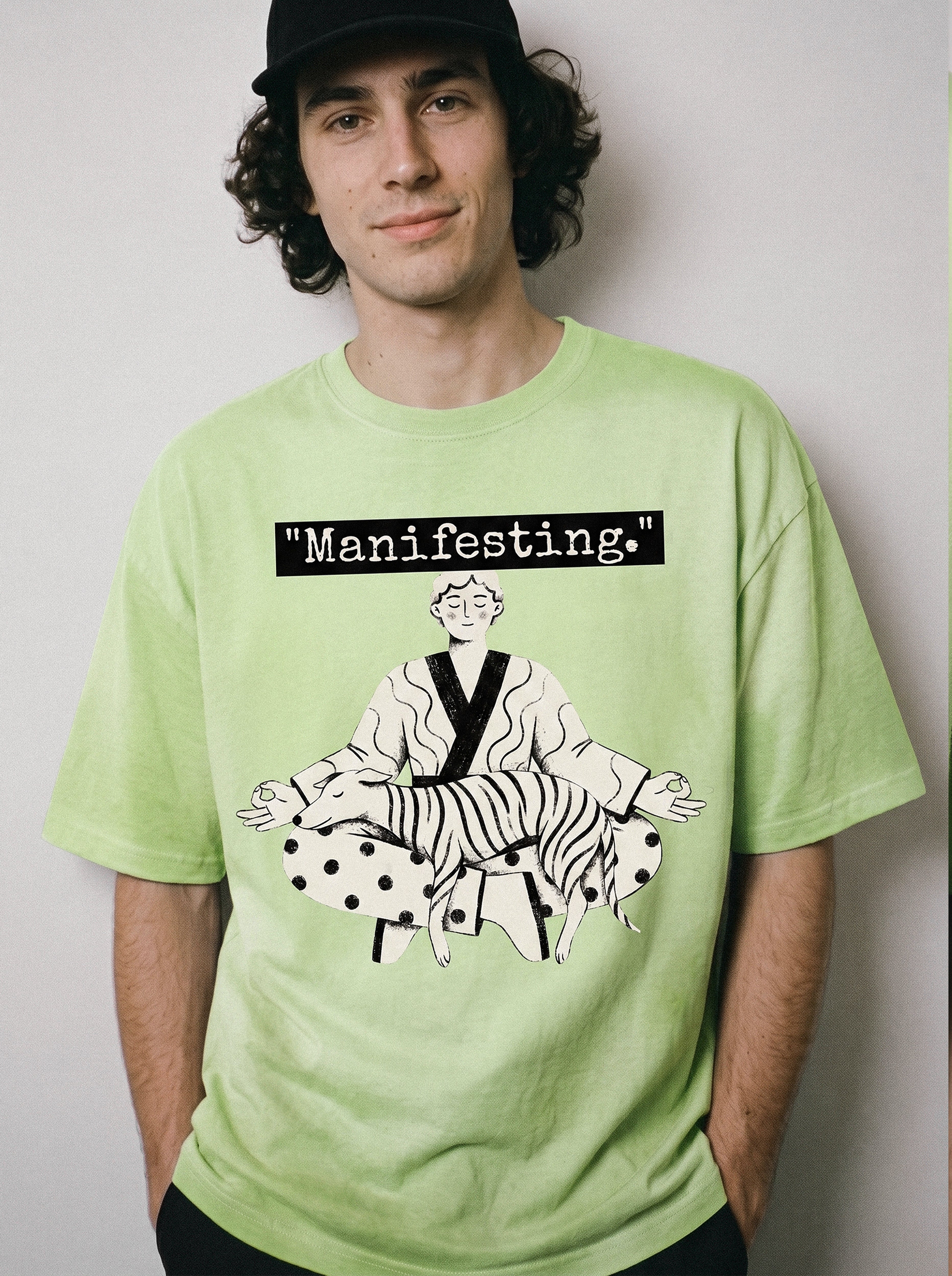 A front view of a male model wearing an acid lime manifesting meditating graphic tee, emphasizing the relaxed boxy fit and objective manifesting line art graphic.
