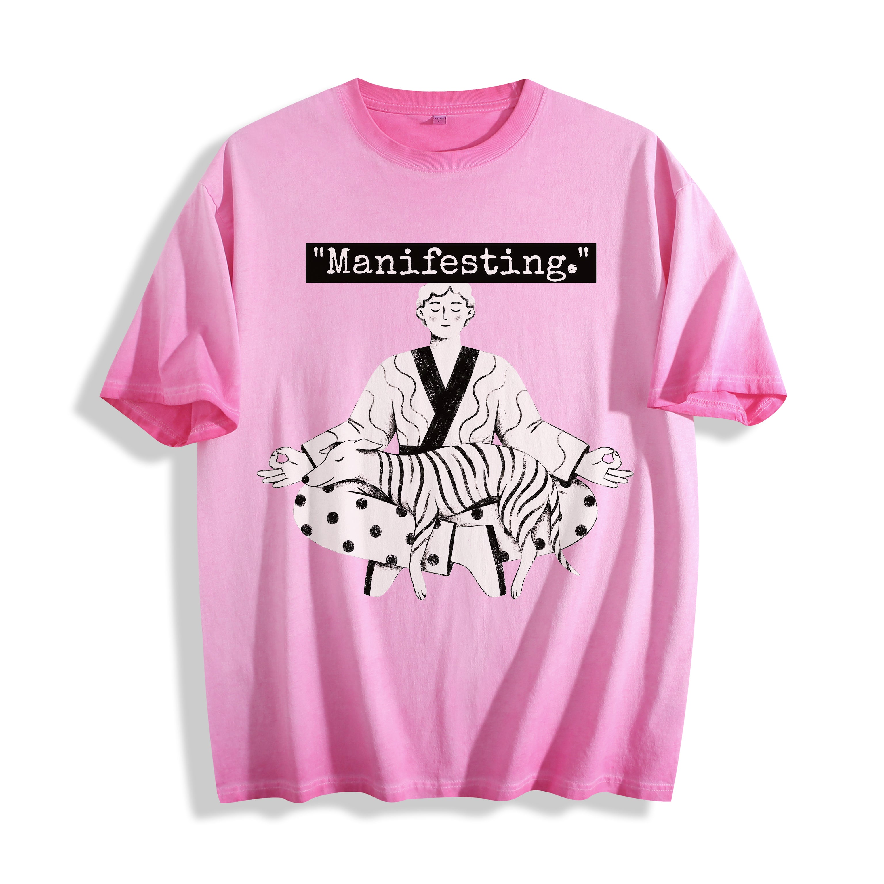 A flat lay of an aura pink manifesting meditating graphic tee, contrasting a soft pastel tone with the objective existential line art illustration.
