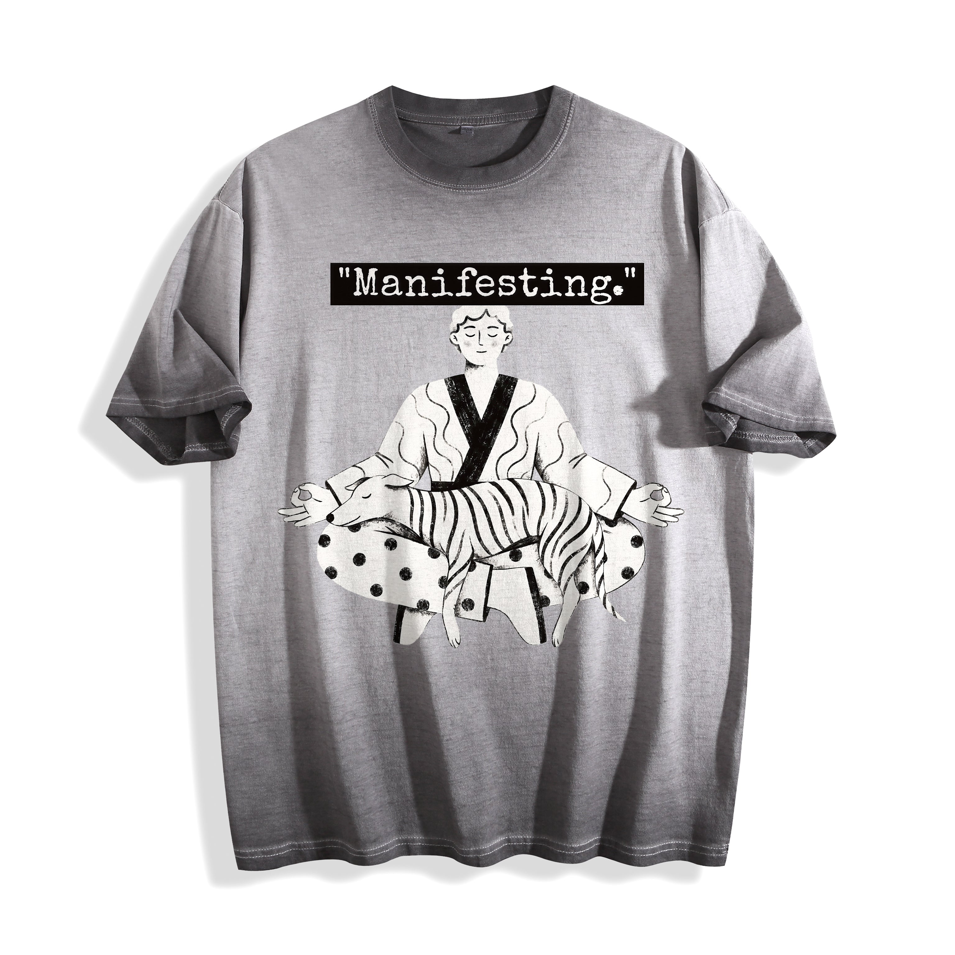 A flat lay of an ombre grey manifesting meditating graphic tee, showcasing the cross-legged boy and dog line art design on a versatile neutral background.