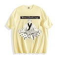 A flat lay of a butter yellow meditating boy and dog line art graphic tee, featuring the manifesting typography and crisp monochrome manga print on a clean background.
