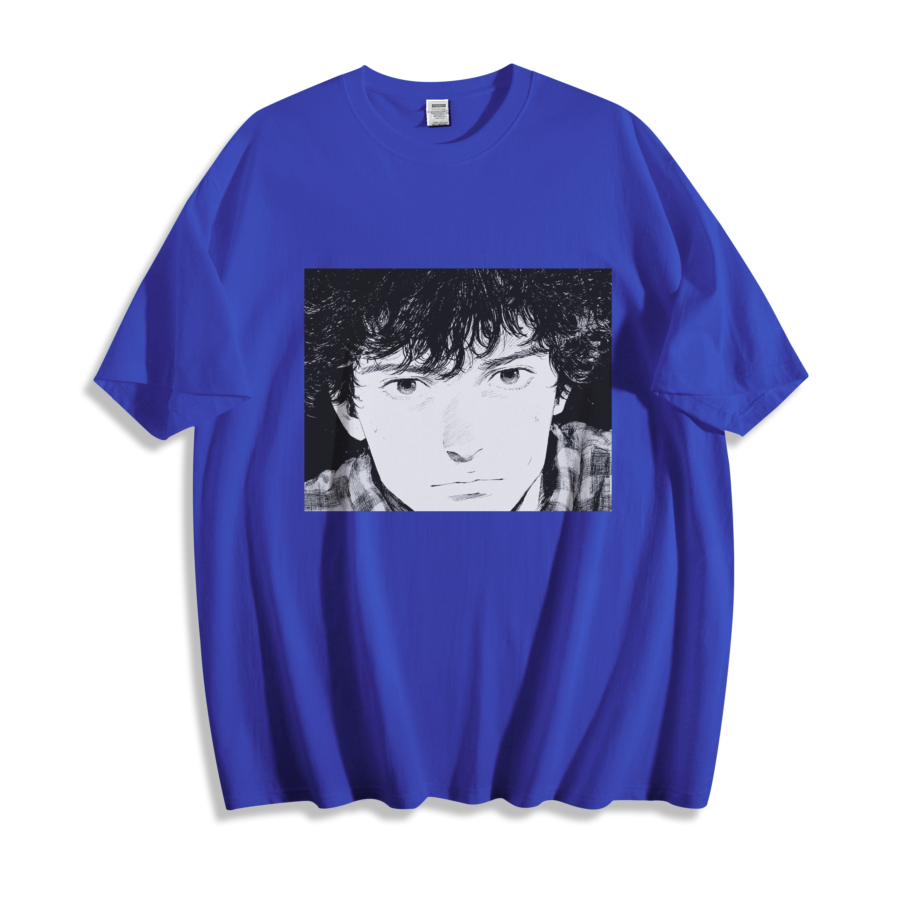 A flat lay of a blue messy hair manga portrait graphic tee, contrasting a vibrant base color with the nostalgic monochrome manga print.