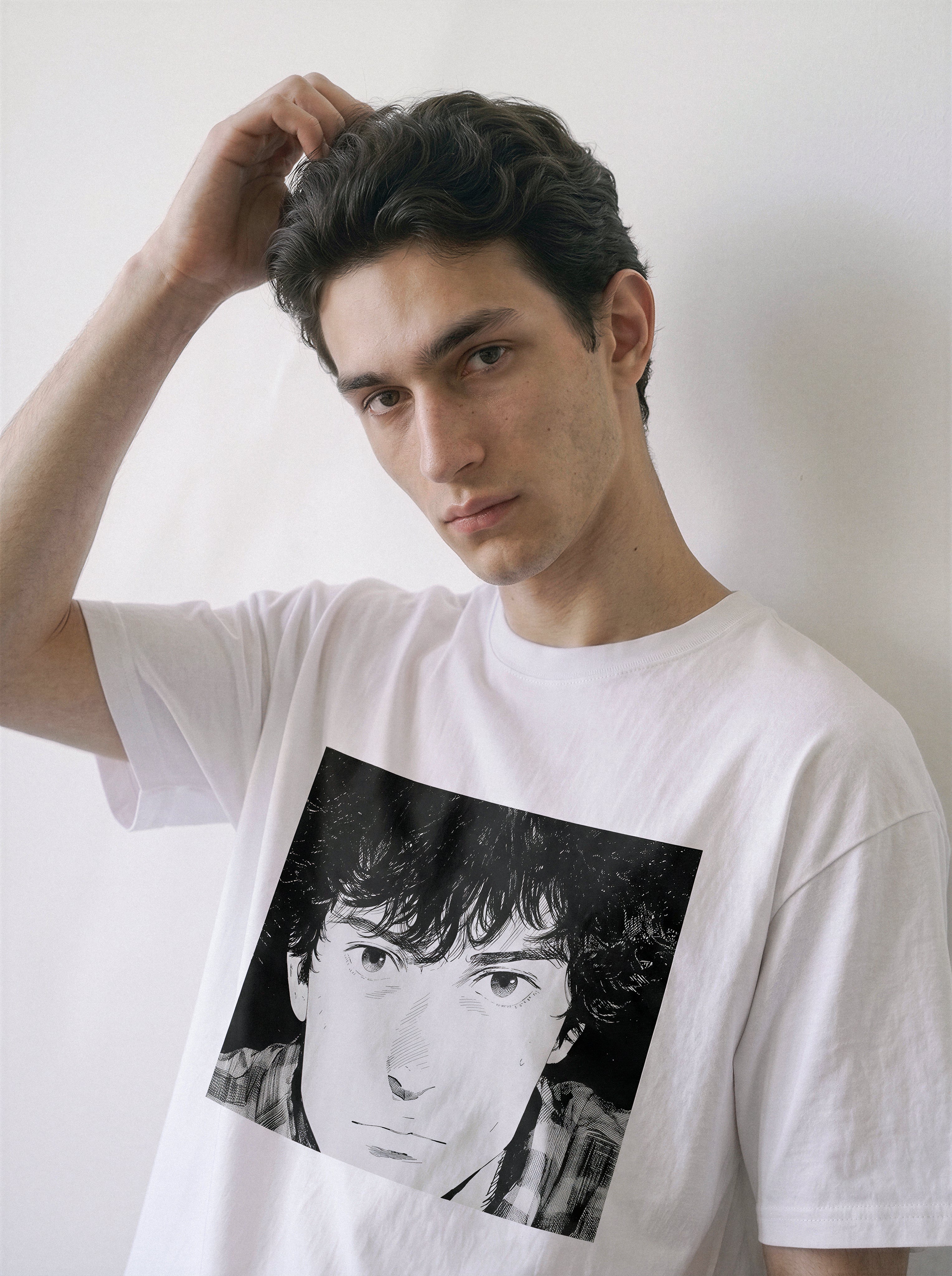 A male model with his hand in his hair posing in a white messy hair manga portrait graphic tee, capturing the vintage youth vibe and raw graphic detail.