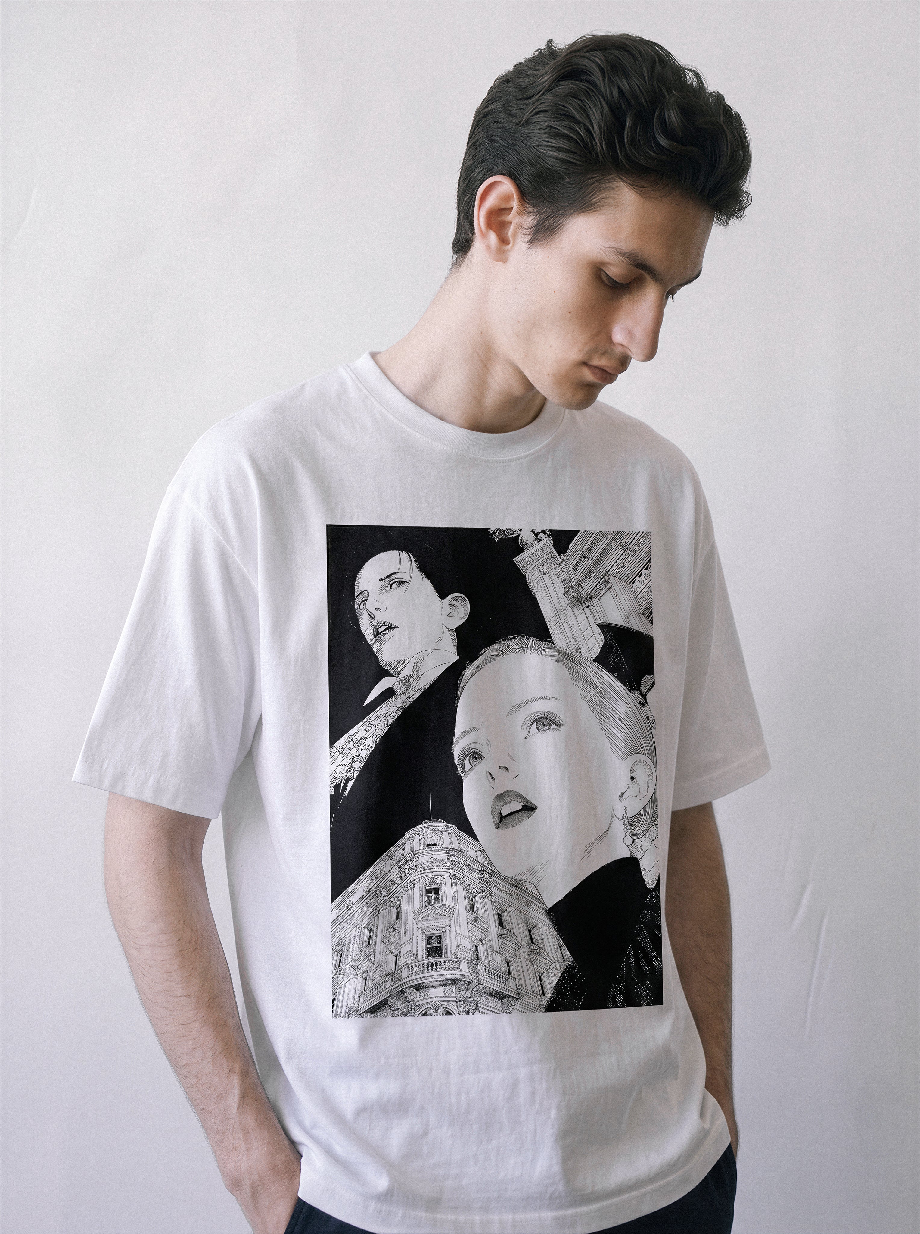 A male model looking down wearing a white monochrome upward gaze graphic tee, emphasizing the silent generational shift and old world monument print.