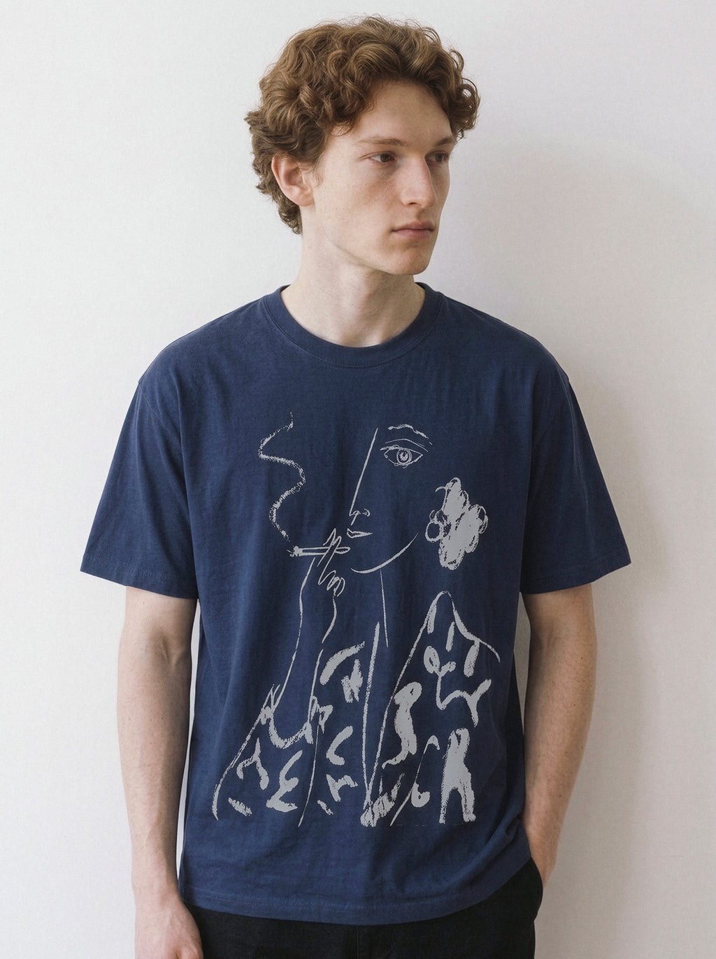 Front view of a male model wearing a navy oversized t-shirt, highlighting the minimalist chalk smoking portrait line art design.