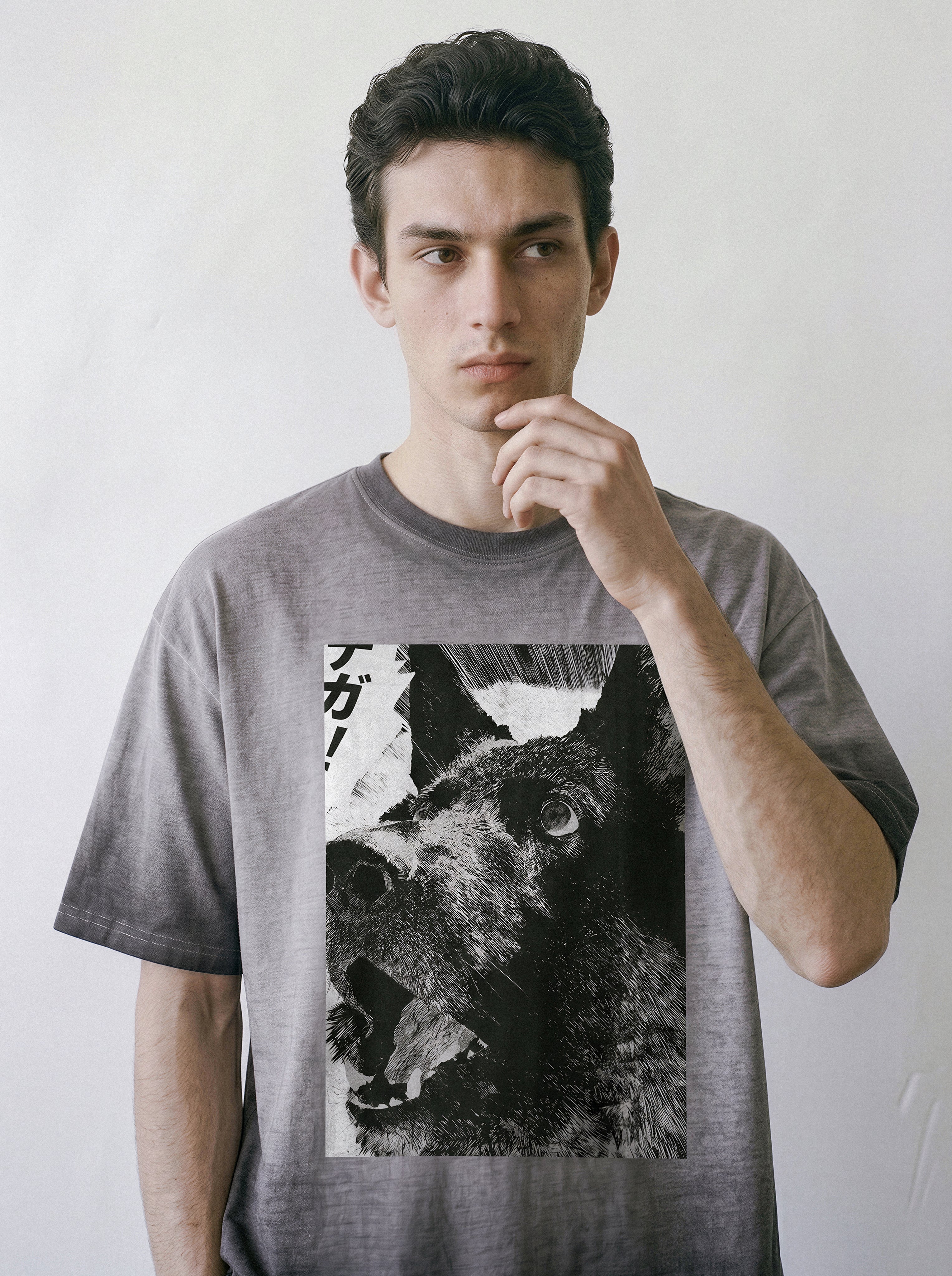A man touching his chin, demonstrating the relaxed drape of an ombre grey heavyweight boxy fit t-shirt with a cute comic panel dog graphic.