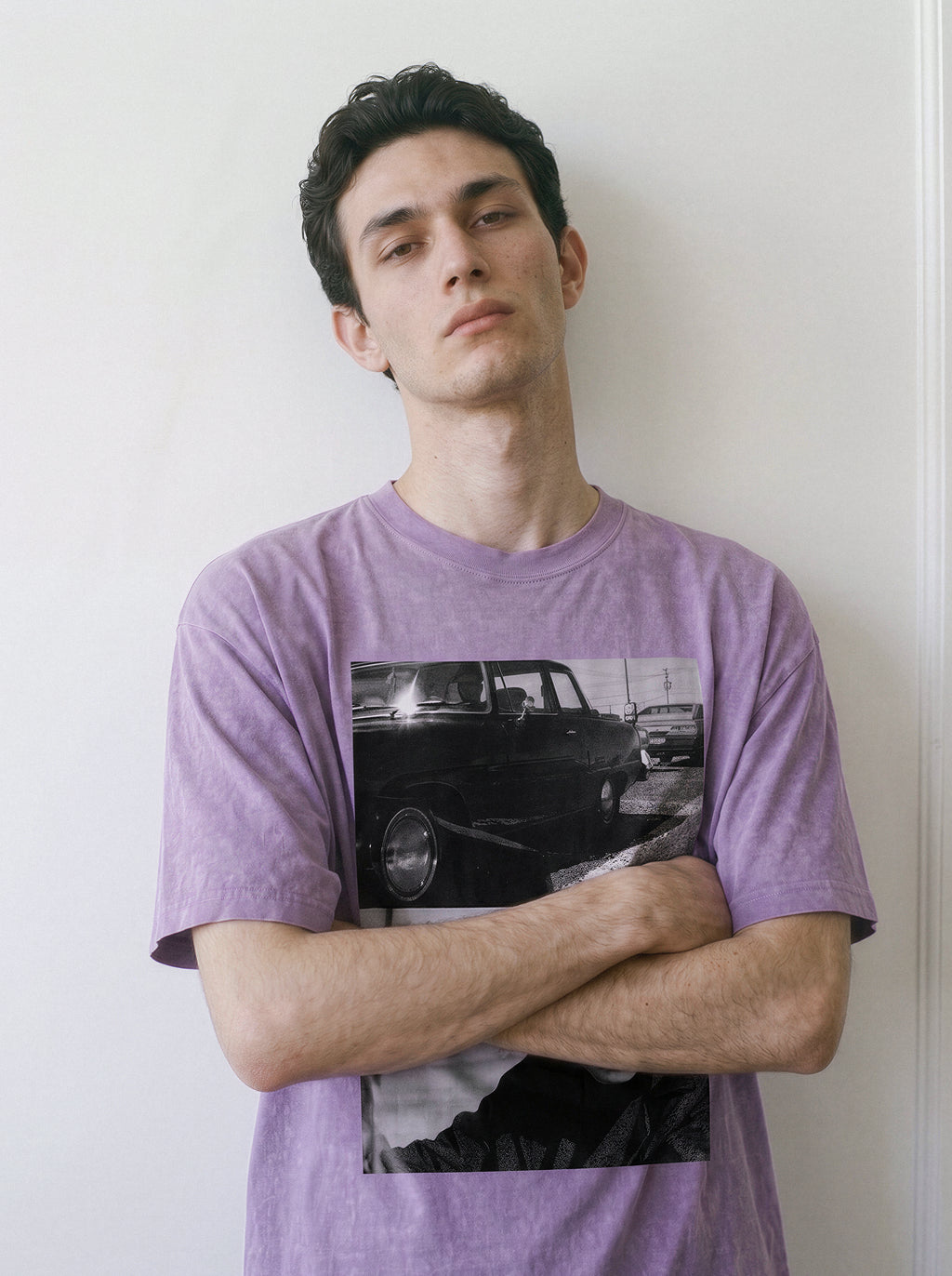 Front view of a model standing with arms crossed, demonstrating the heavyweight cotton fit of an ombre violet Yakuza aesthetic tee with a striking car and lone-wolf print.