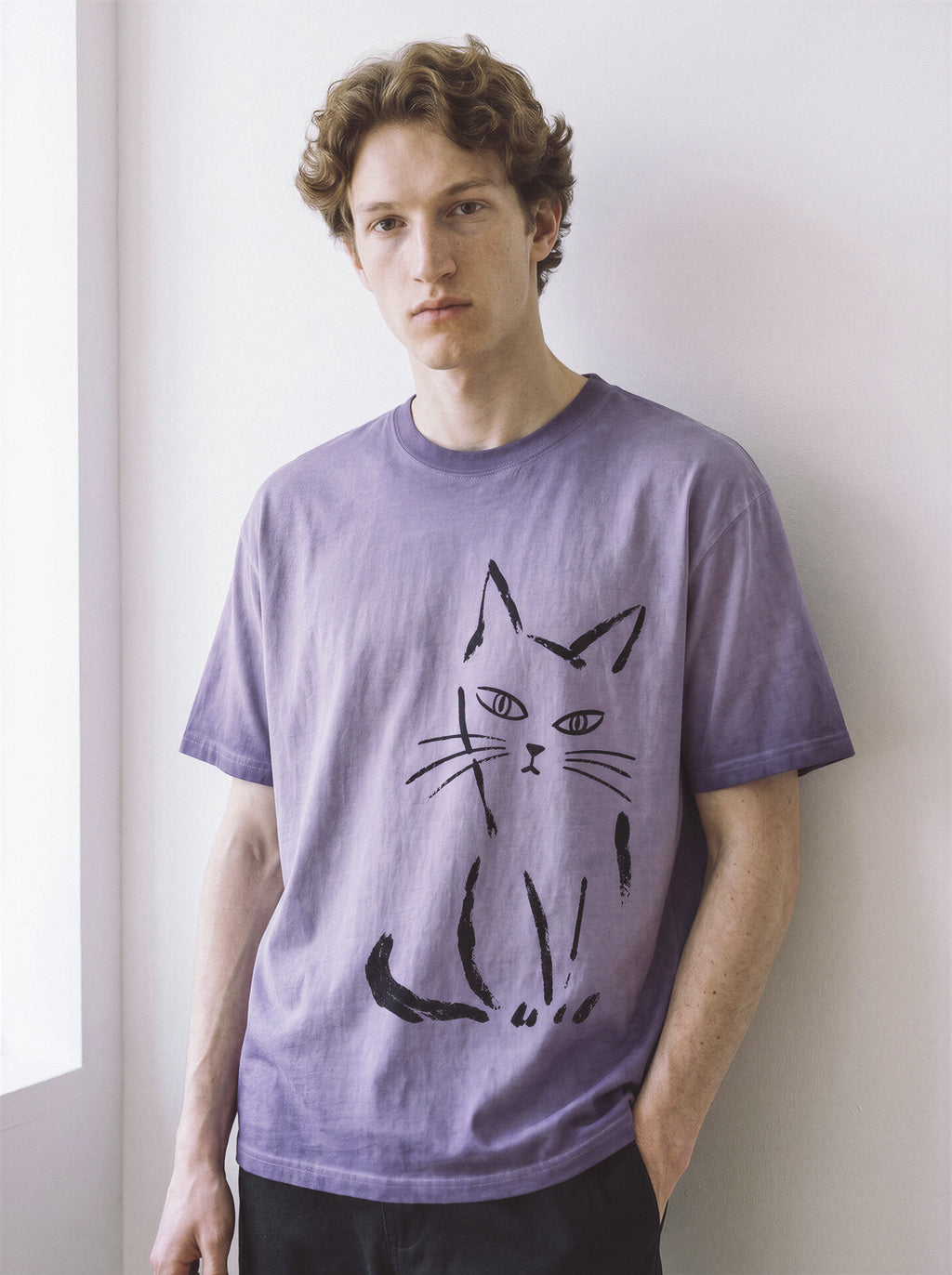 Front view of a model in a relaxed stance, demonstrating the drape of an ombre violet 230g premium cotton tee highlighting a messy paint stroke feline design.