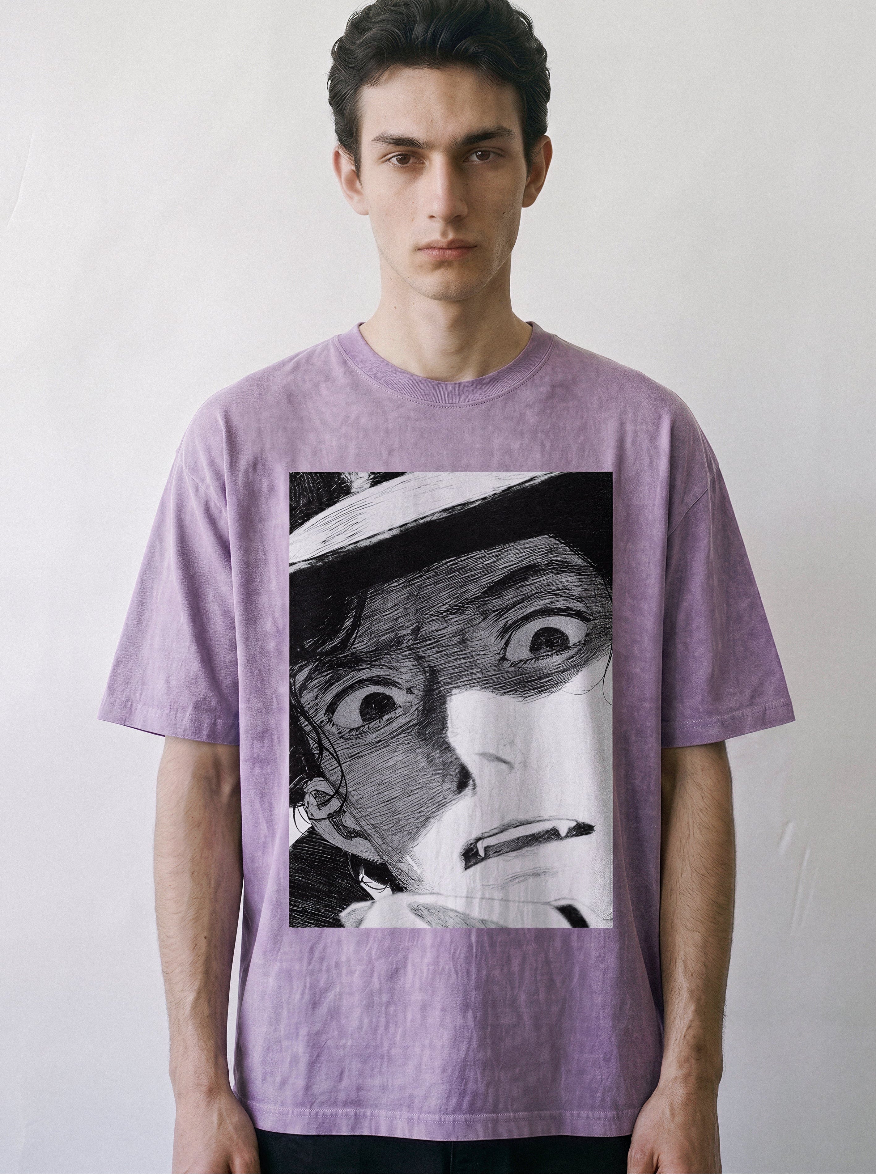 Front portrait of a male model looking directly at the camera, wearing an ombre violet heavyweight boxy fit graphic tee featuring a vintage black-and-white shocked manga panel illustration.