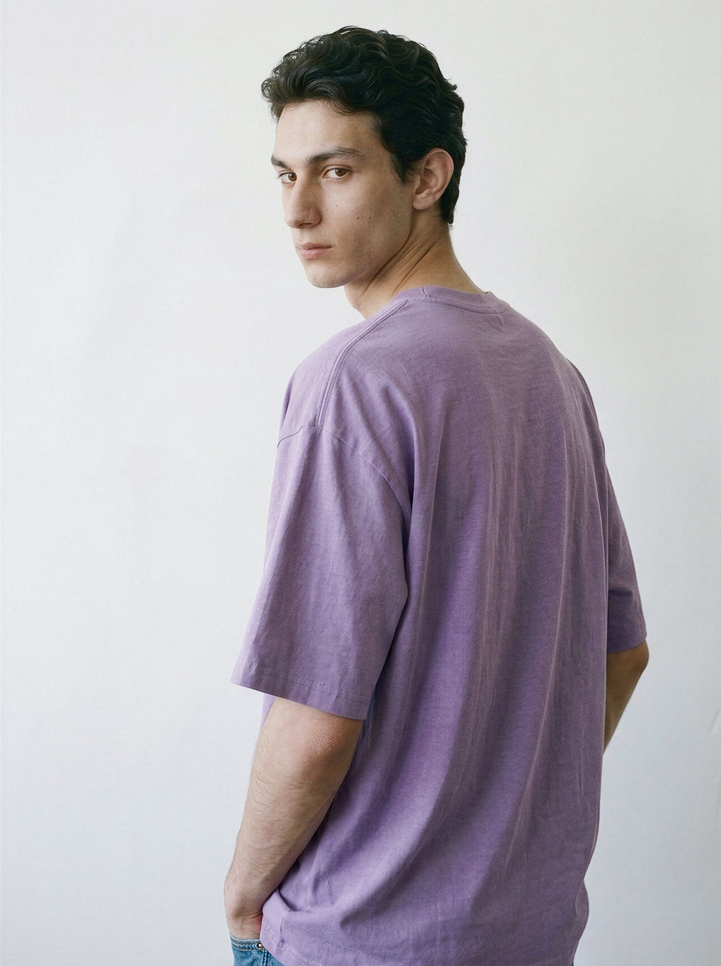 Back and side angle view of a male model demonstrating the relaxed, structured drape of an ombre violet heavyweight boxy fit streetwear t-shirt.