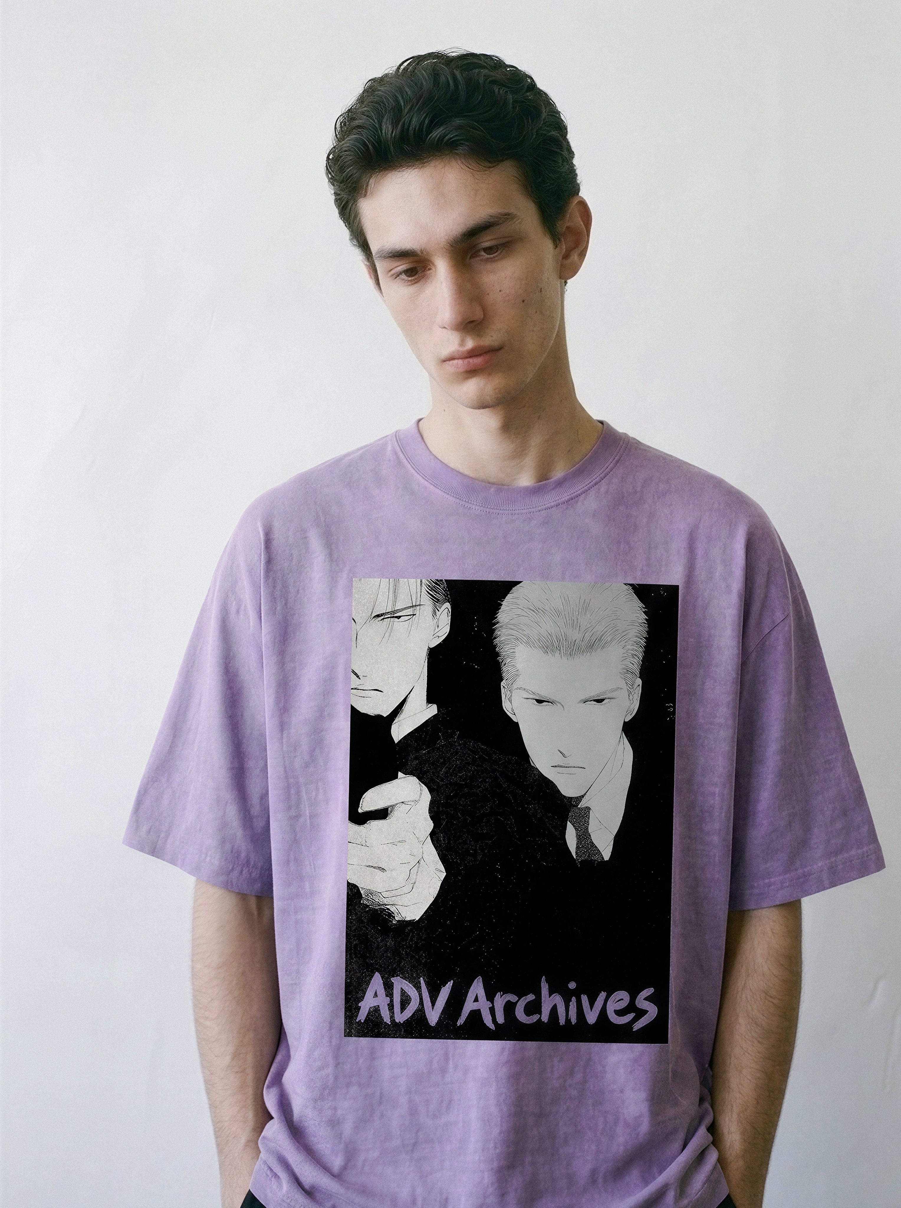 A man wearing a lavender purple t-shirt with a black and white graphic print of anime characters and the text 'ADV Archives' on the front, set against a plain light gray background.