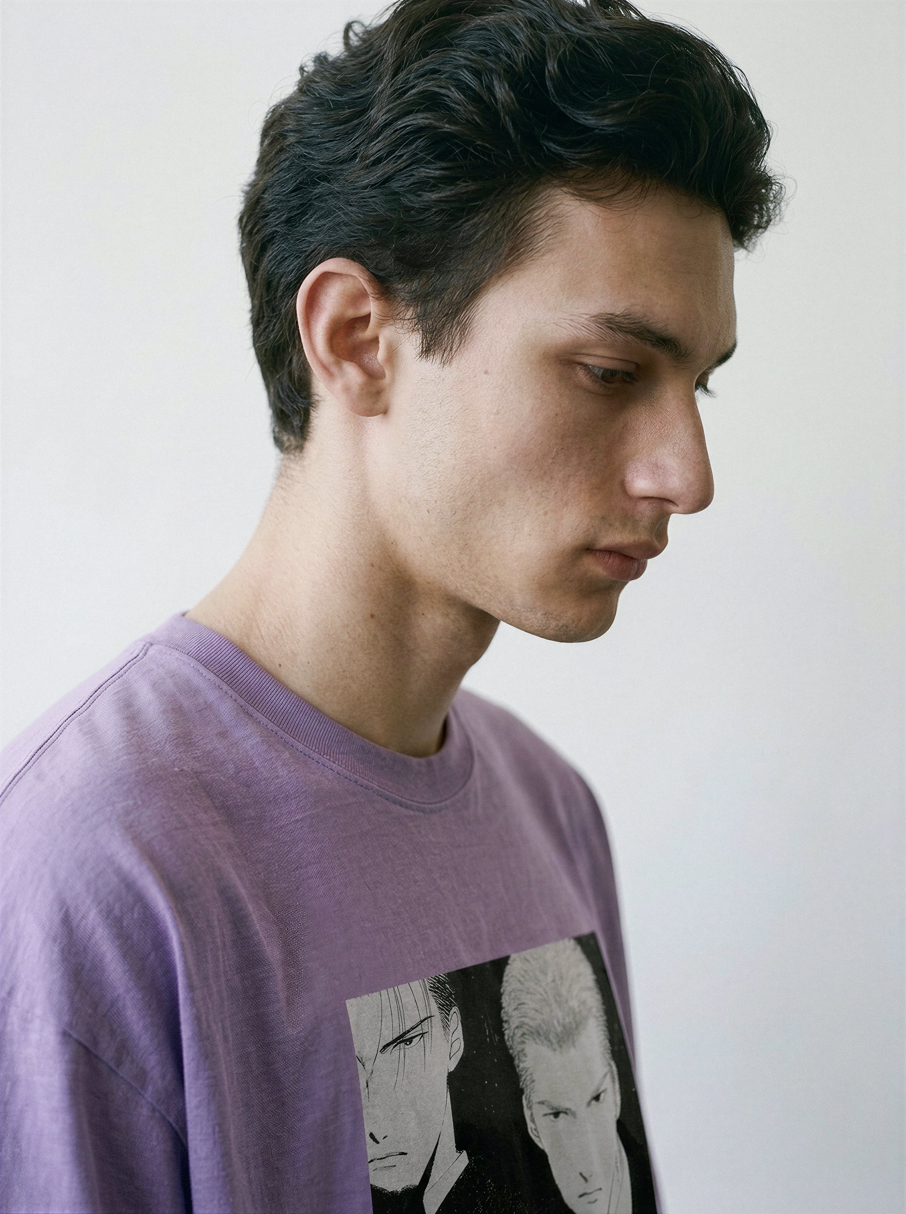 Side profile close-up of a model wearing an ombre violet premium cotton tee with a hardboiled Yakuza execution comic panel design.