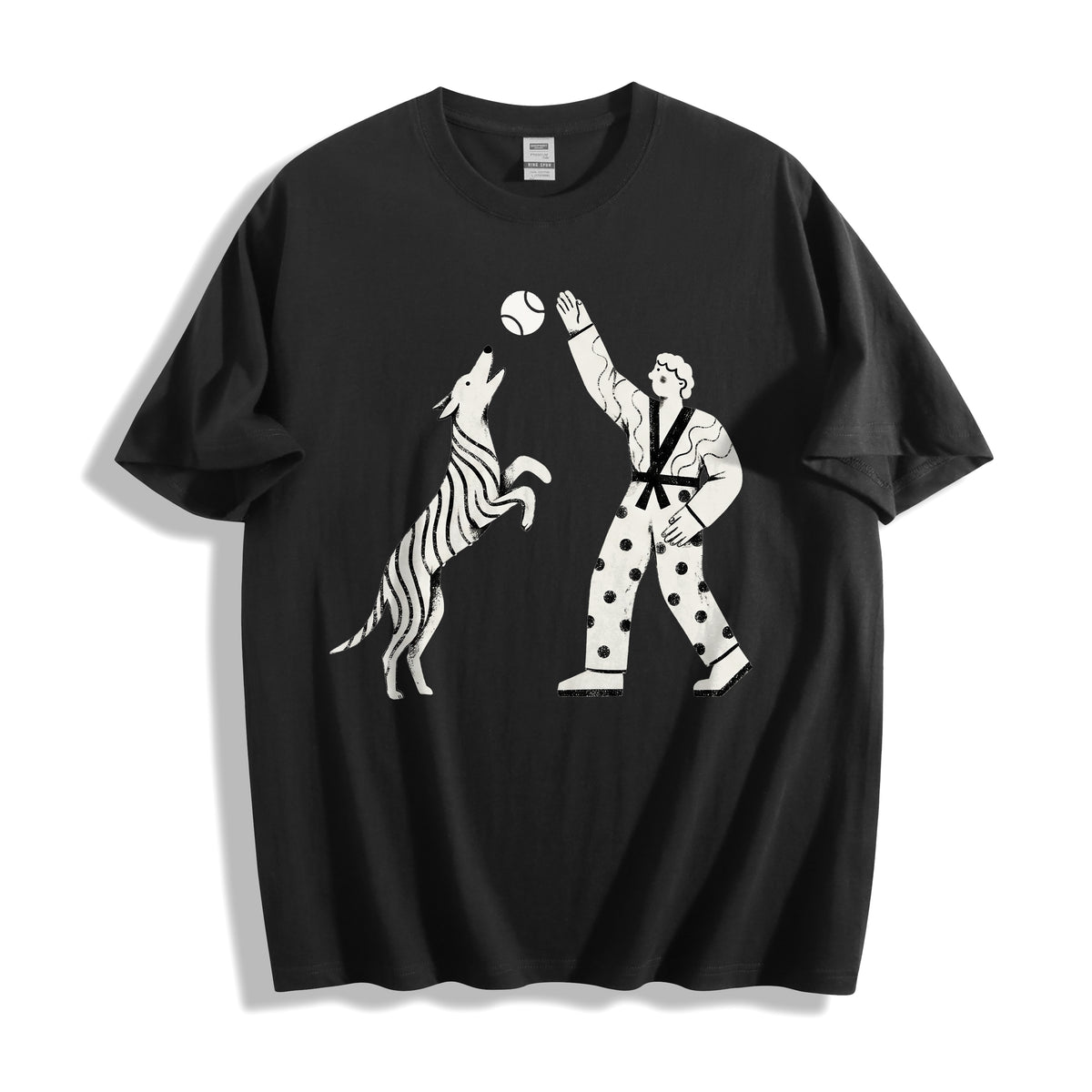 A flat lay of a black playing fetch ironic graphic tee, contrasting a dark base with the quirky micro-control dry humor design.