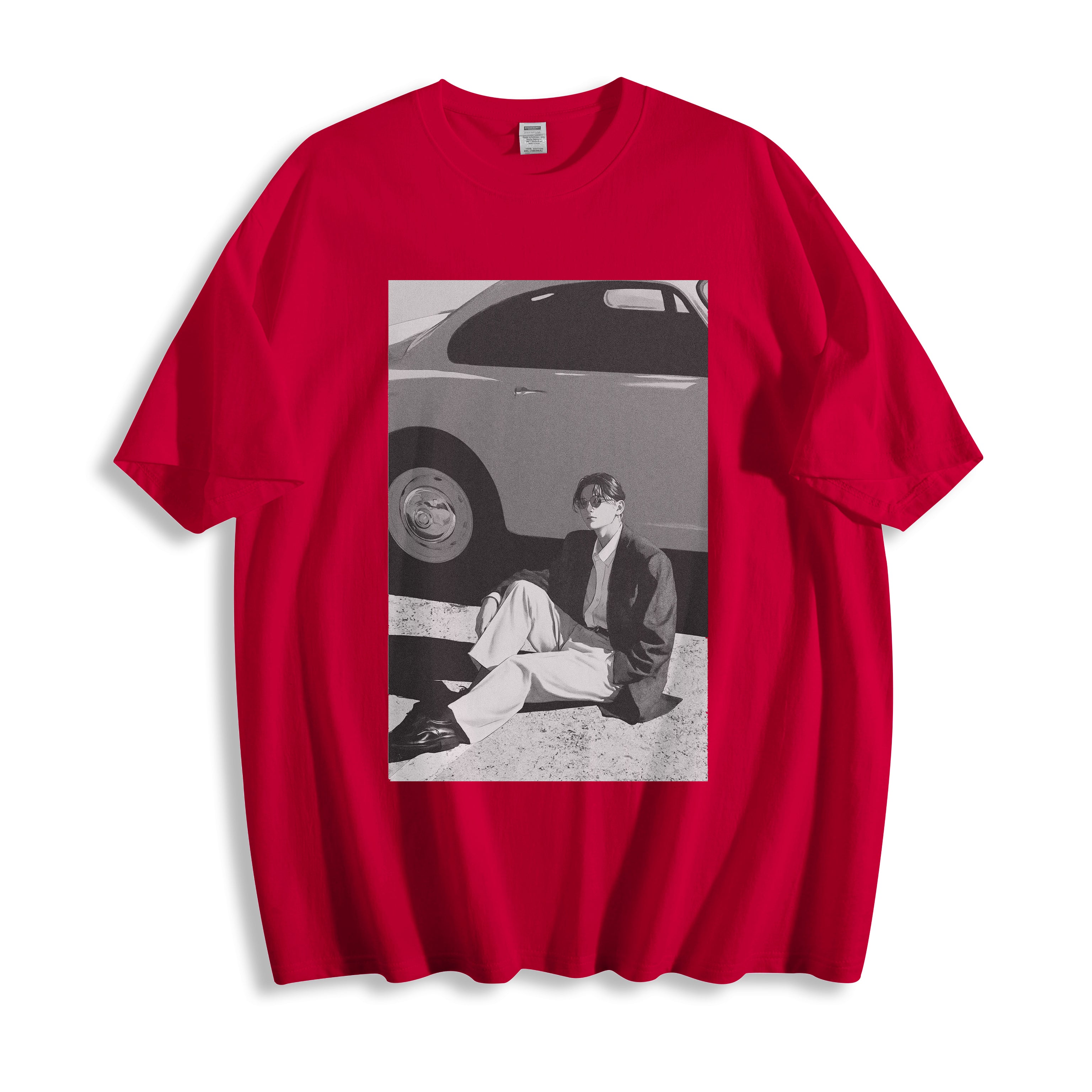 Flat lay product view of a red oversized streetwear t-shirt featuring a 90s retro cinematic black and white photography print, showing a person sitting next to a car. 