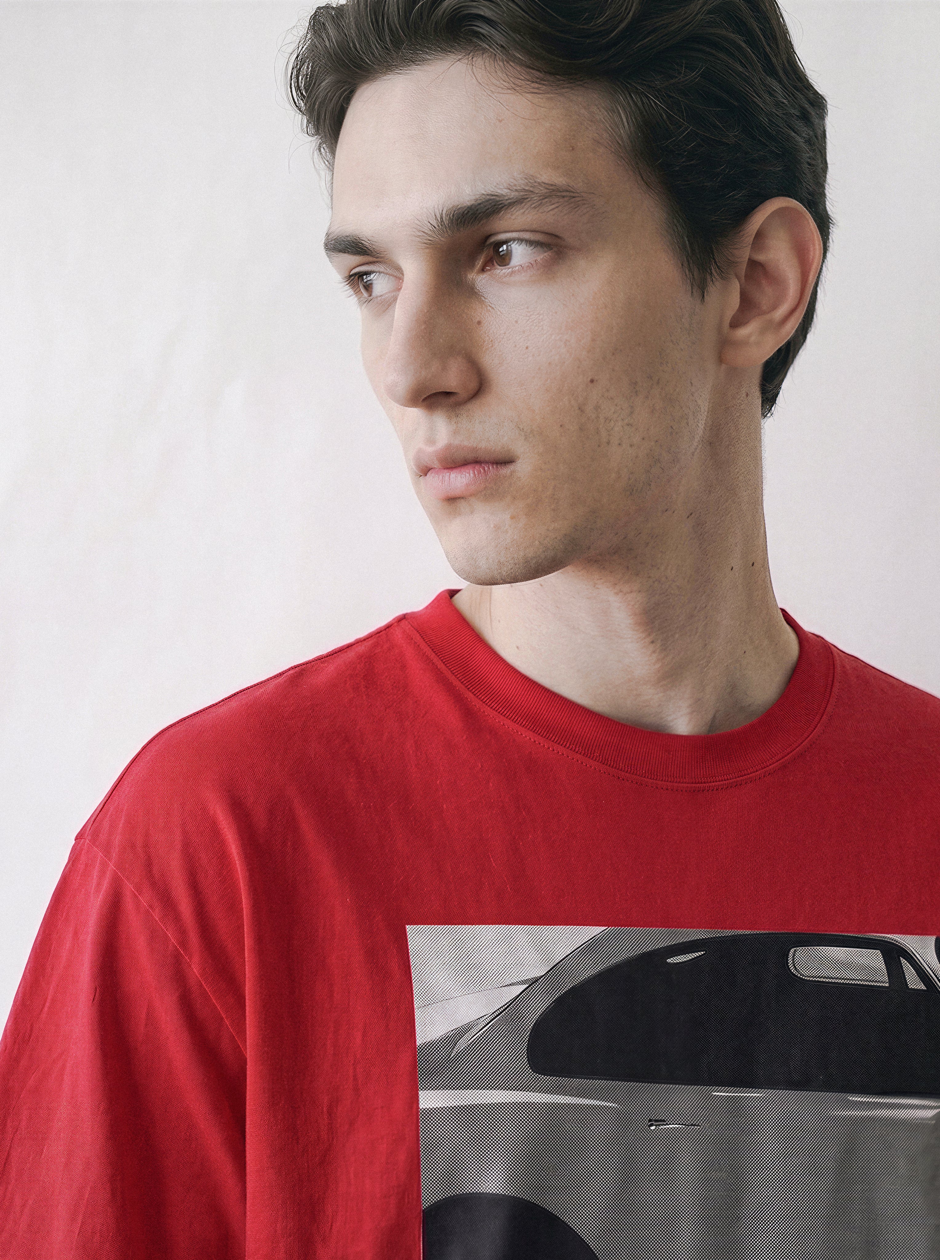 Close-up shot of a model looking right, highlighting the neckline and shoulder structure of a red 90s retro cinematic graphic t-shirt.