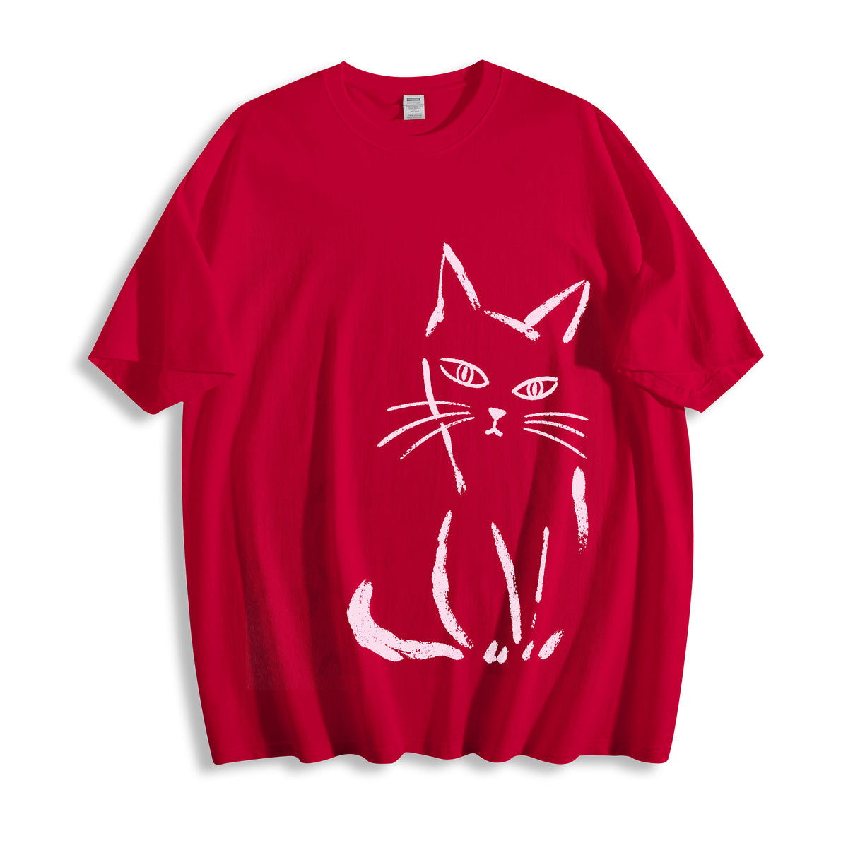 Flat lay product photography of a bold red oversized graphic tee featuring a clean paint stroke judgmental cat graphic.