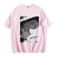 A flat lay of a light pink shocked face manga panel graphic tee, displaying the high-contrast monochrome retro manga illustration on a soft pastel base.