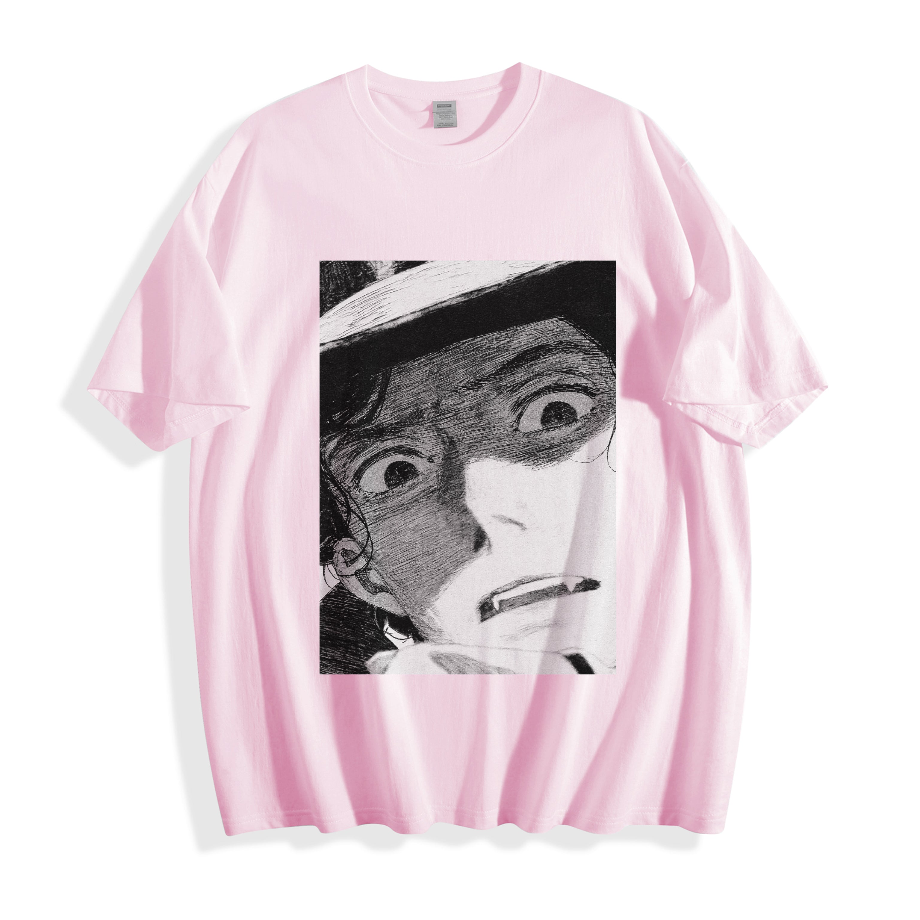 A flat lay of a light pink shocked face manga panel graphic tee, displaying the high-contrast monochrome retro manga illustration on a soft pastel base.