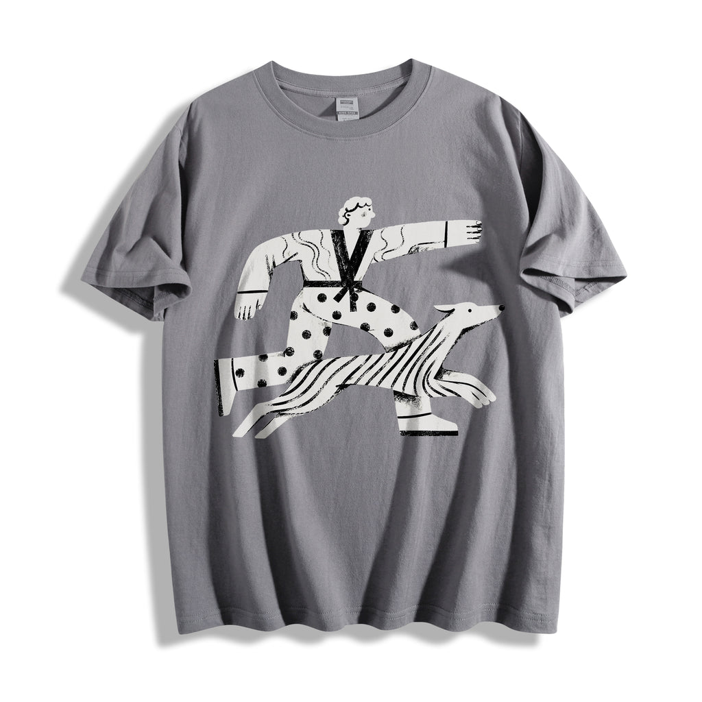 A flat lay of a gray striding away line art graphic tee, featuring a pure line art print of a person and dog striding with absolute conviction.