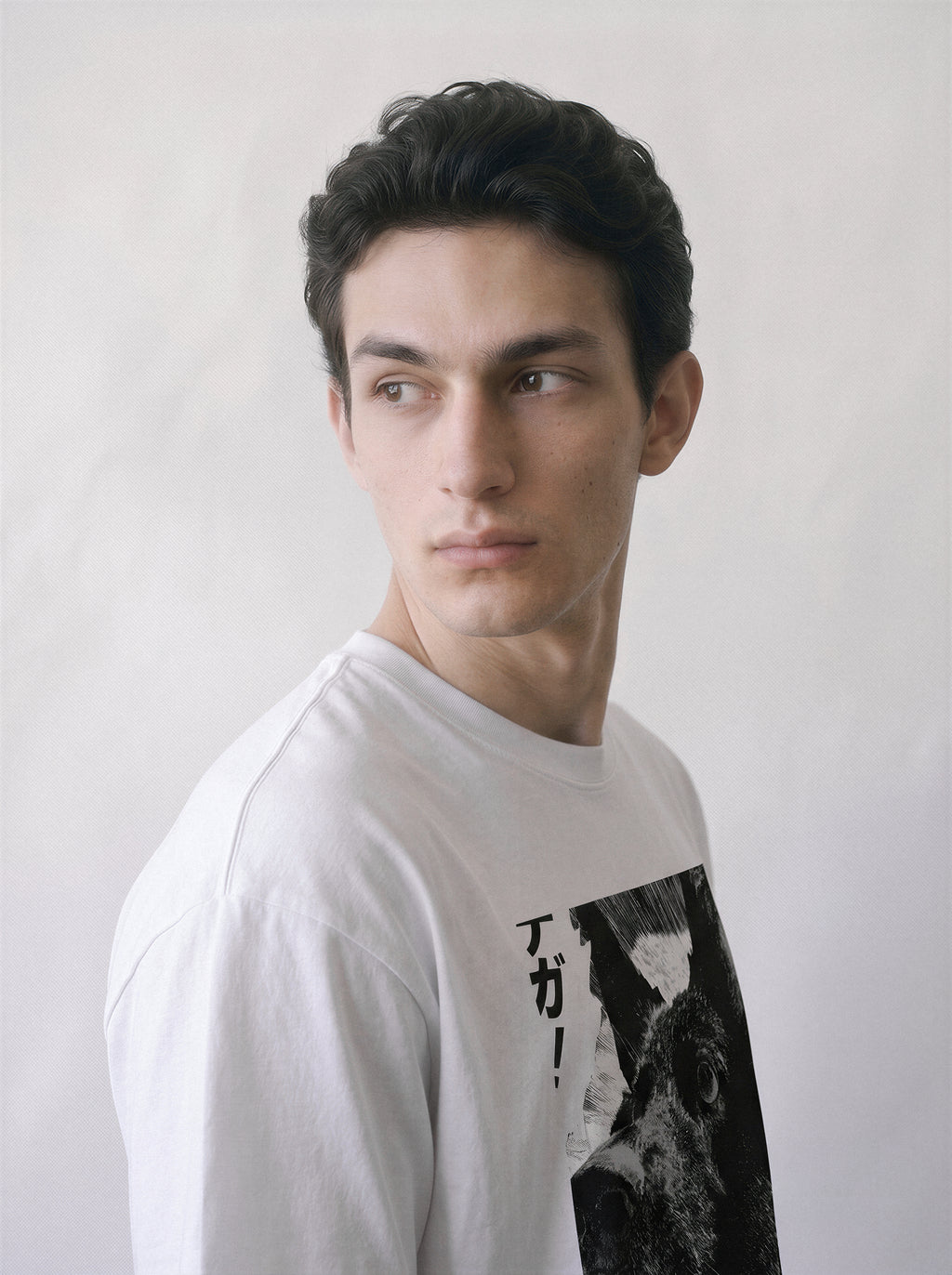 A male model looking over his shoulder wearing a white surprised dog comic panel graphic tee, capturing the striking texture and instinctual reaction graphic design.