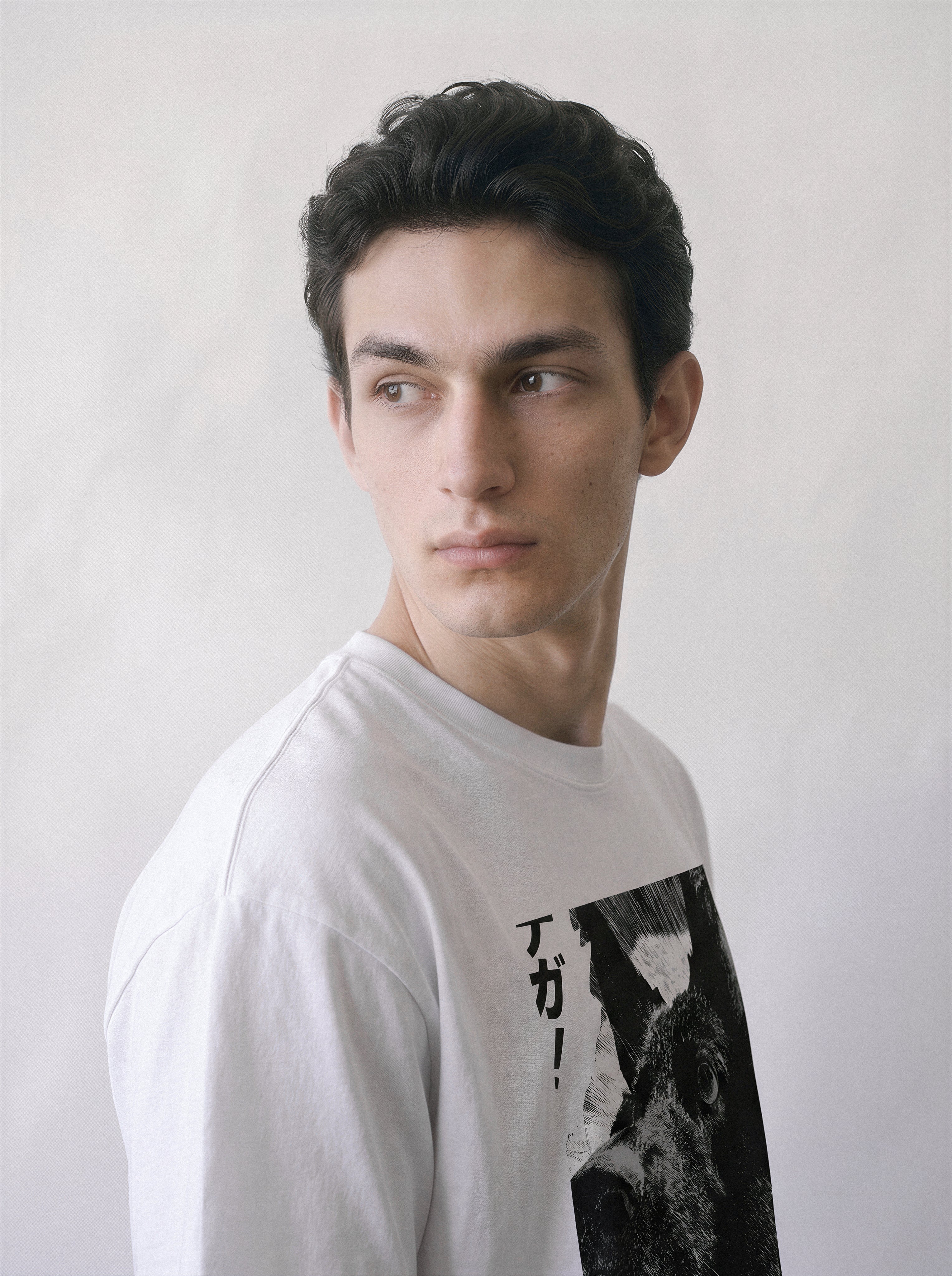 A male model looking over his shoulder wearing a white surprised dog comic panel graphic tee, capturing the striking texture and instinctual reaction graphic design.
