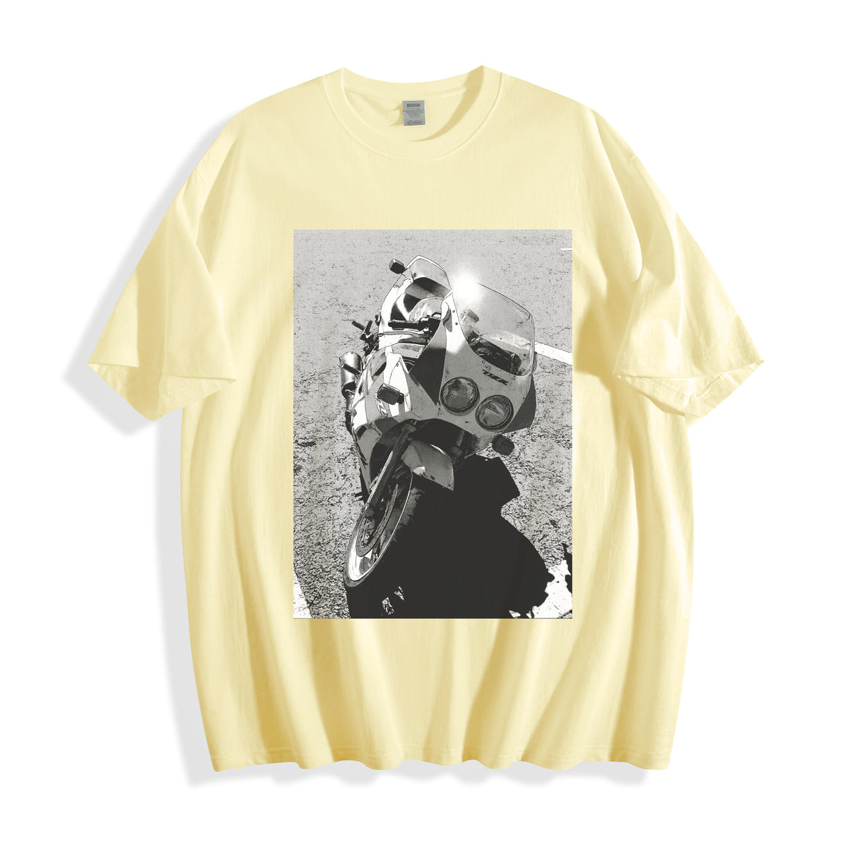 A flat lay of a butter yellow 90s monochrome motorcycle photography tee, blending a soft pastel tone with a raw mechanical sportbike photography print.