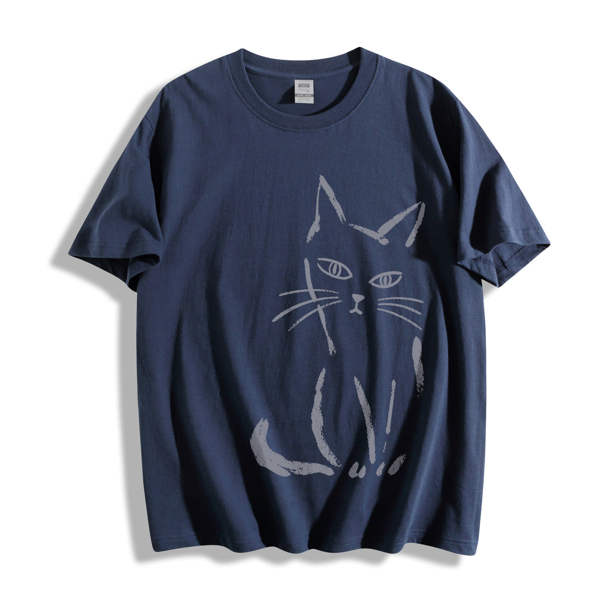 Top-down flat lay view of a vintage navy oversized streetwear t-shirt displaying a minimalist judgmental cat line art design.